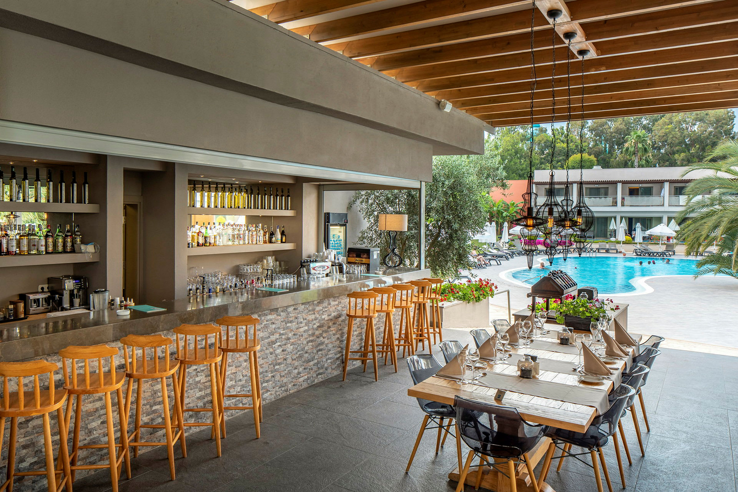En bar vid sidan av en pool med sittplatser och bord. (AI-genererad text)