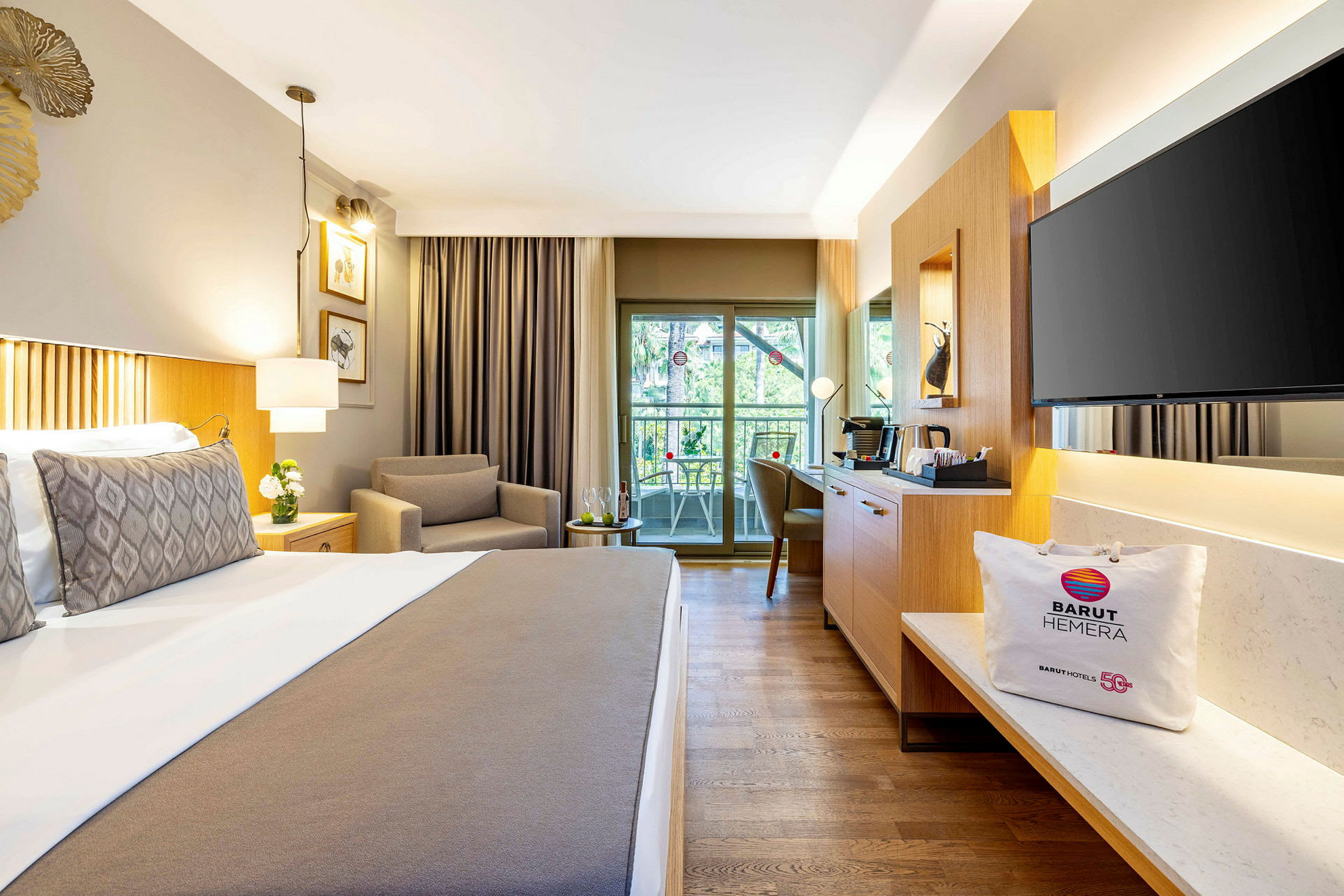 Ett hotellrum med en bekväm säng, en fåtölj, en sittgrupp vid balkongen och moderna möbler. (AI-genererad text)