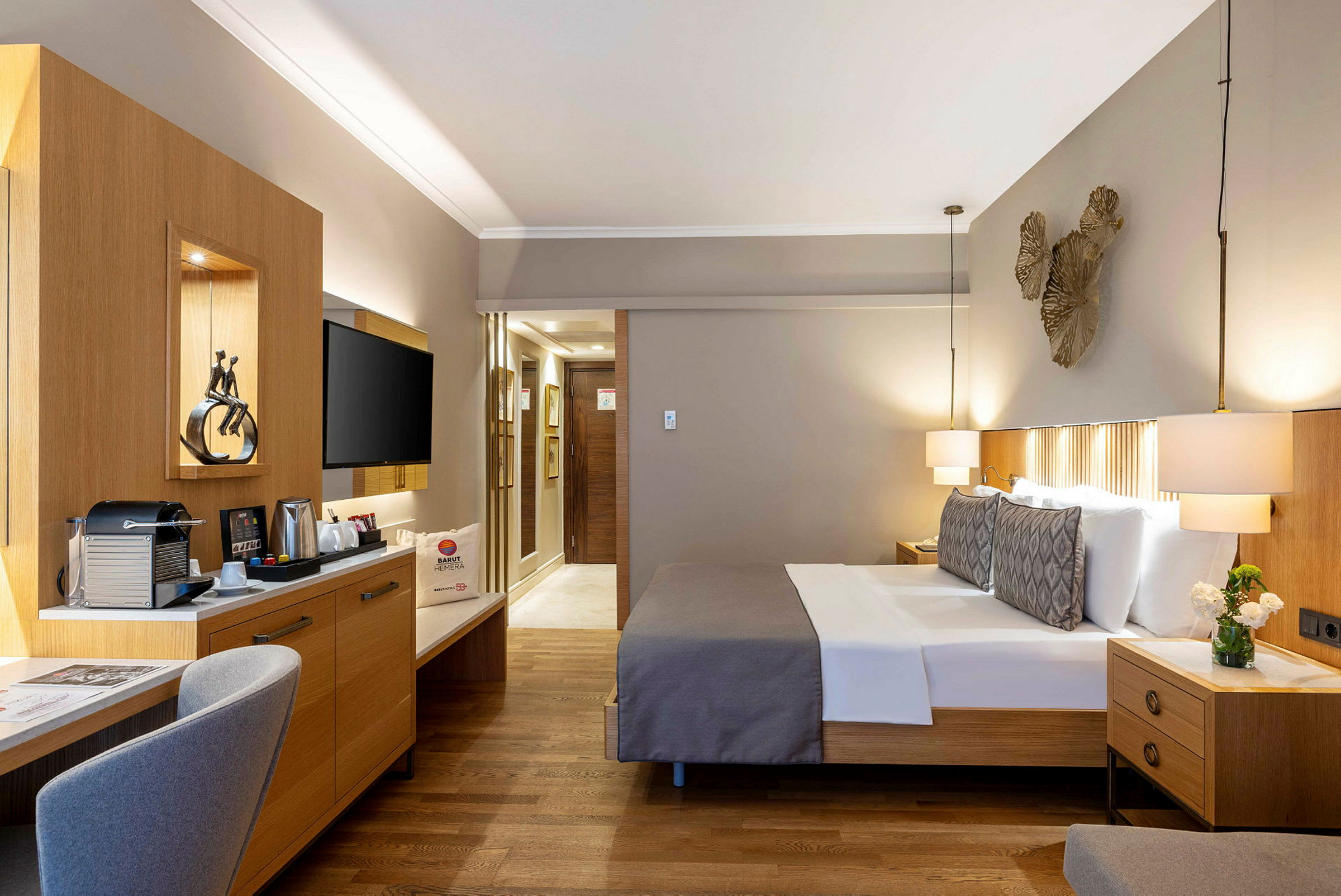 Hotellrum med dubbelsäng, skrivbord och TV. (AI-genererad text)