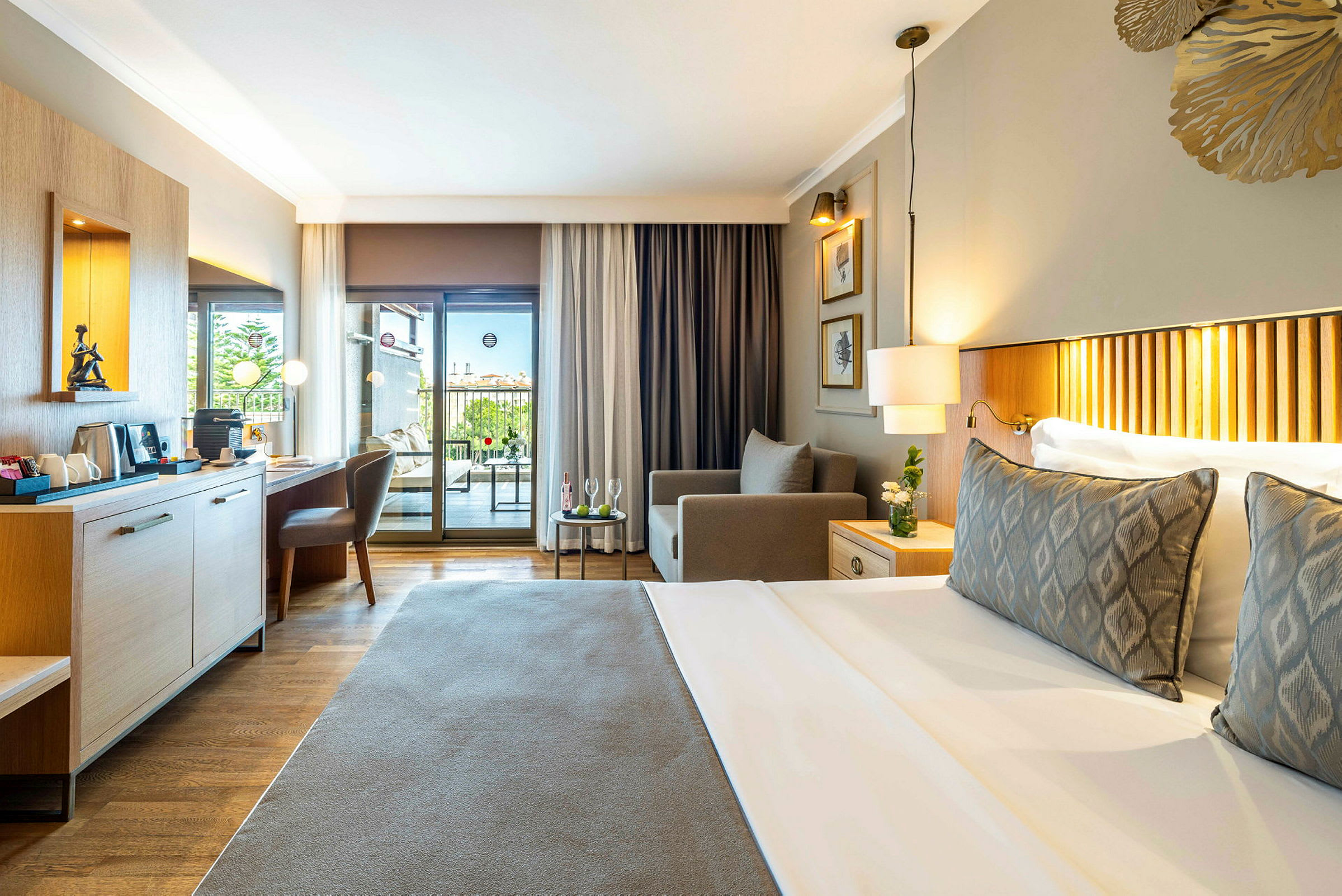 Ett rymligt hotellrum med en dubbelsäng, sittgrupp, skrivbord och balkong med utsikt. (AI-genererad text)