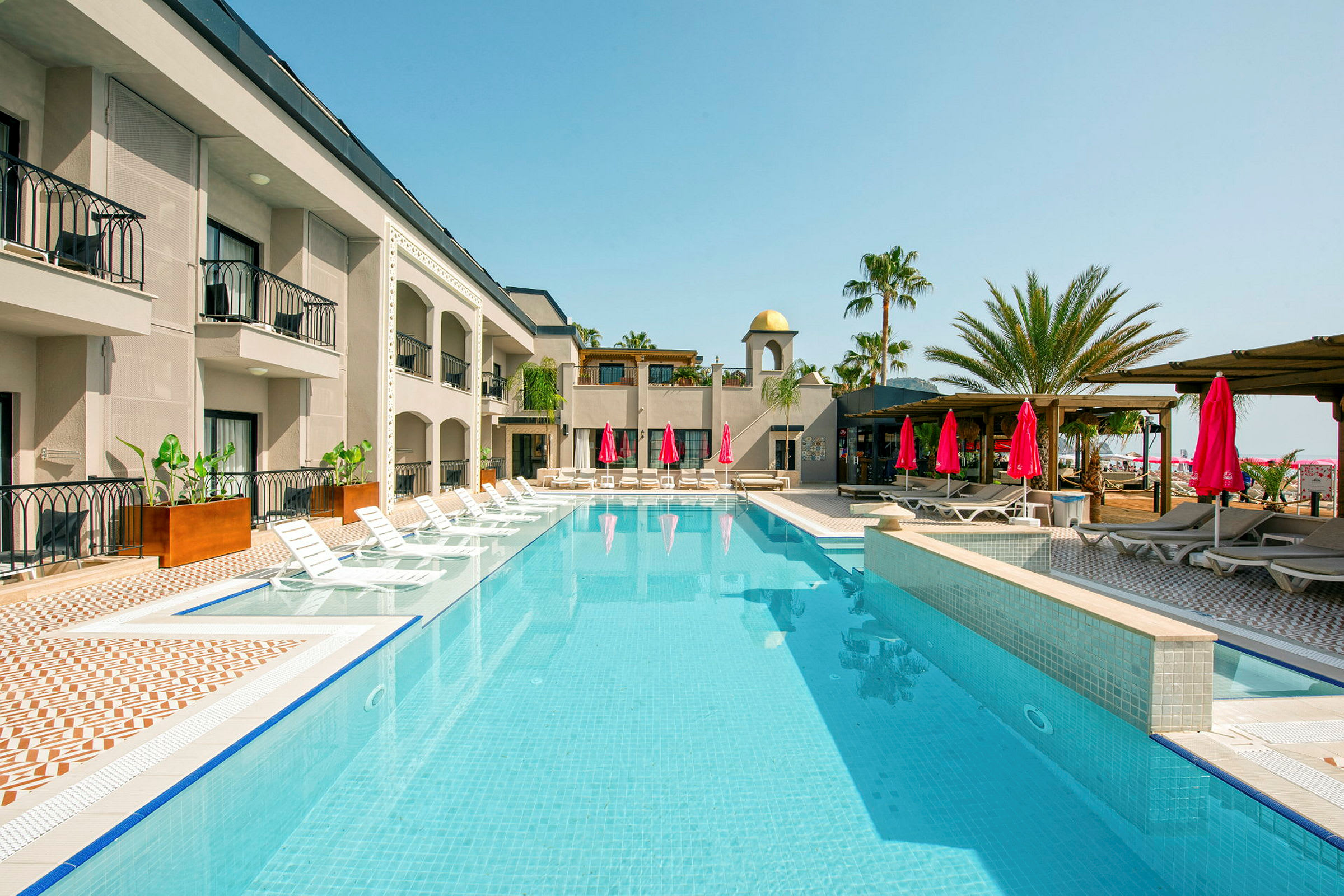 Hotellpool med solstolar och parasoll. (AI-genererad text)