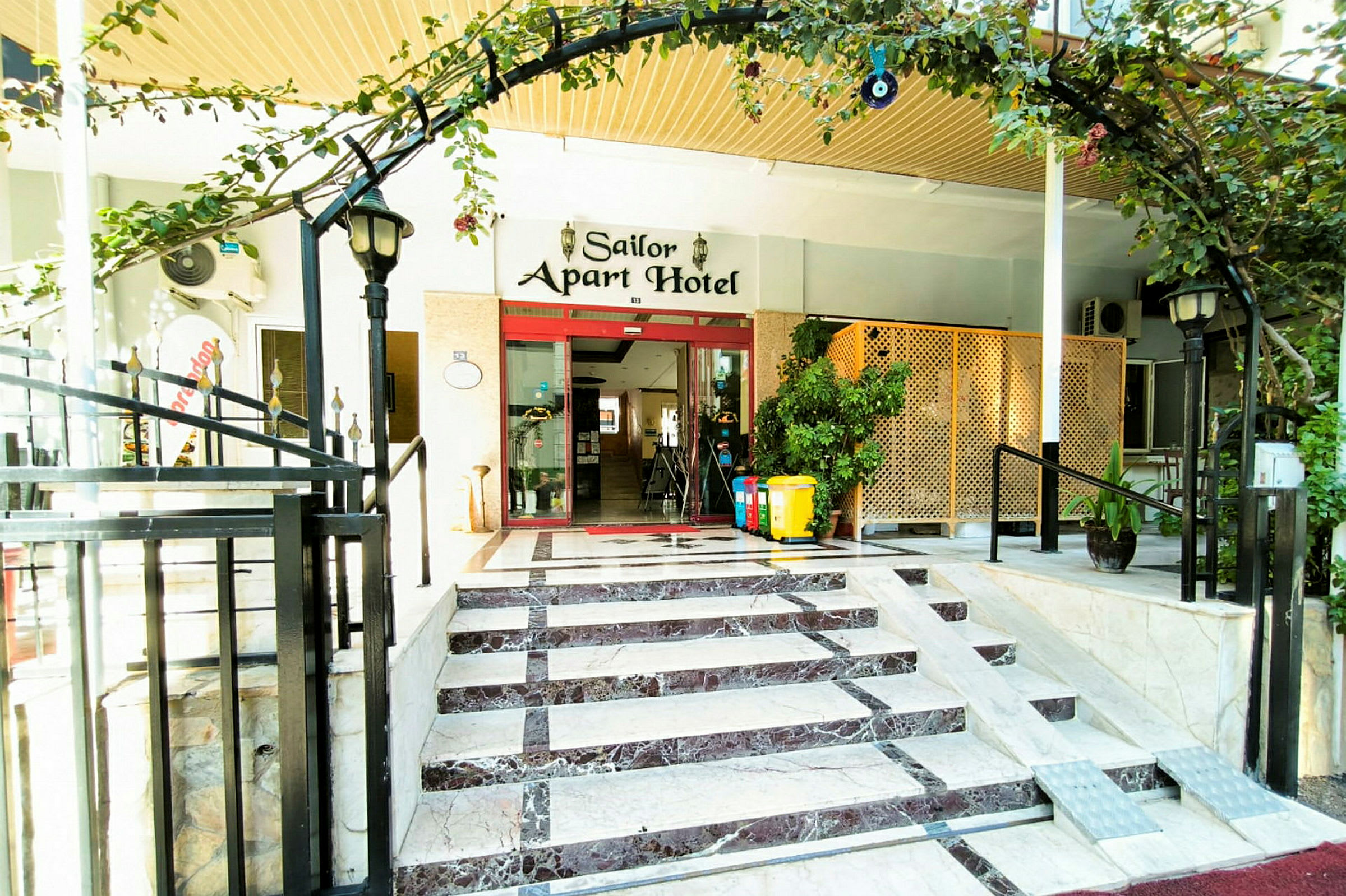 Entré till Sailor Apart Hotel med trappor och ramp. (AI-genererad text)