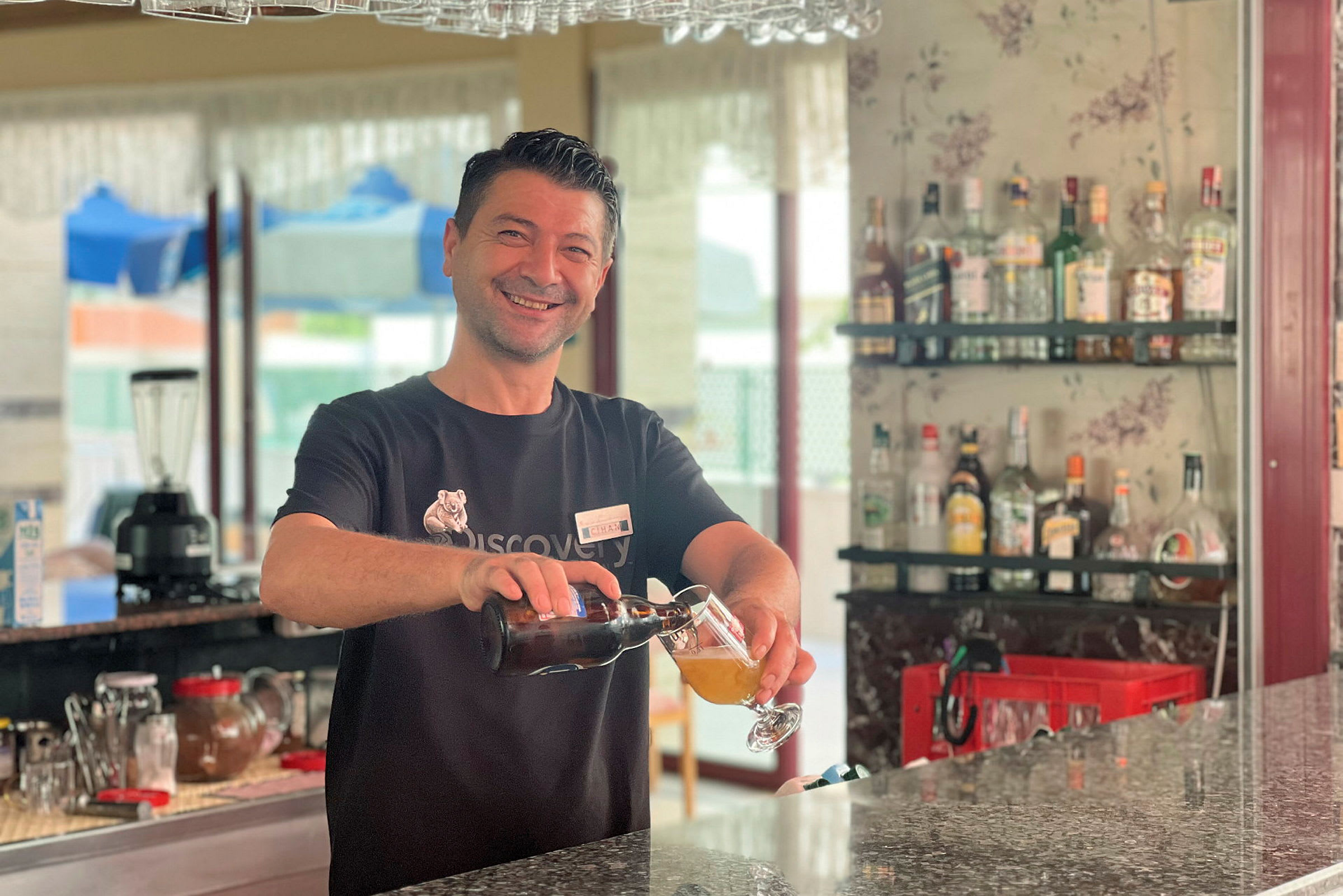 En bartender häller upp en drink vid en bar. (AI-genererad text)