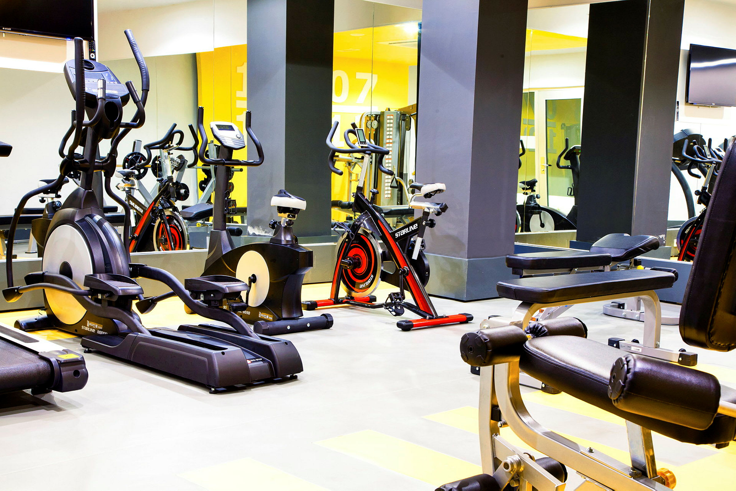 Bild av ett gym med konditionsmaskiner och träningsutrustning. (AI-genererad text)
