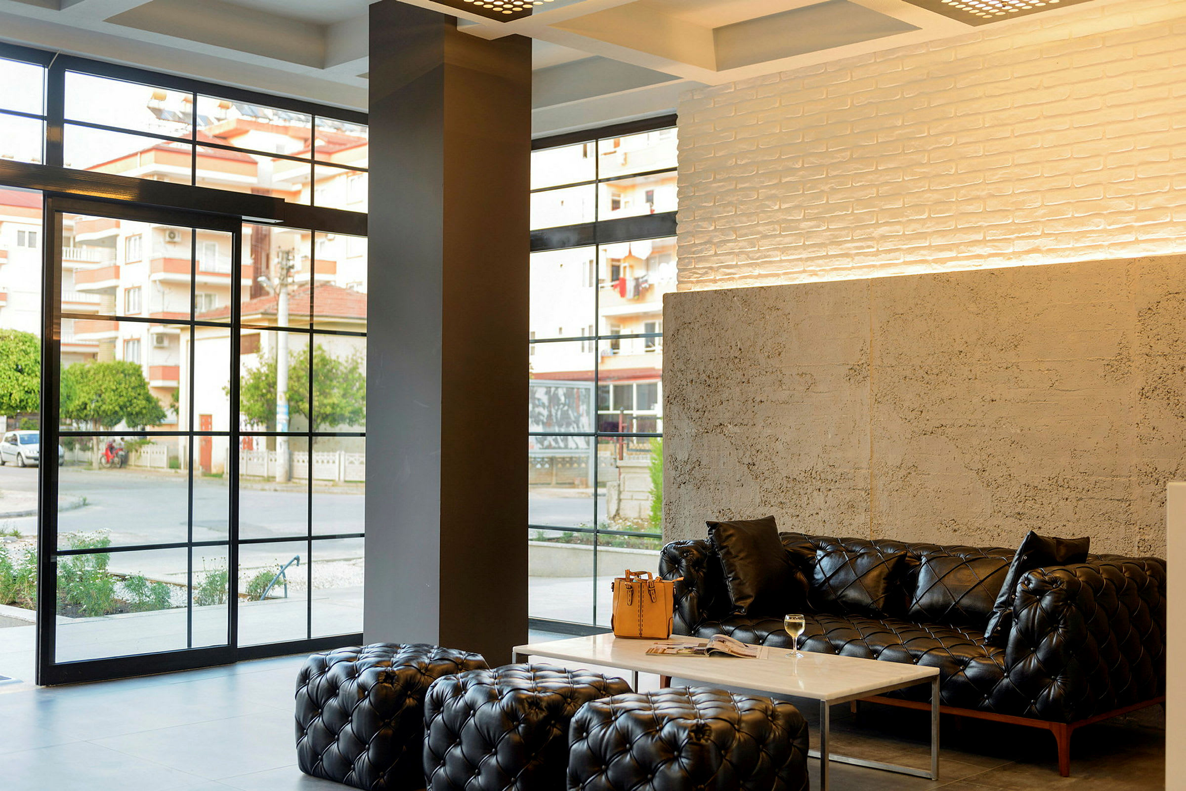 Modern lobby med svarta soffor, ett marmorbord och stora fönster. (AI-genererad text)