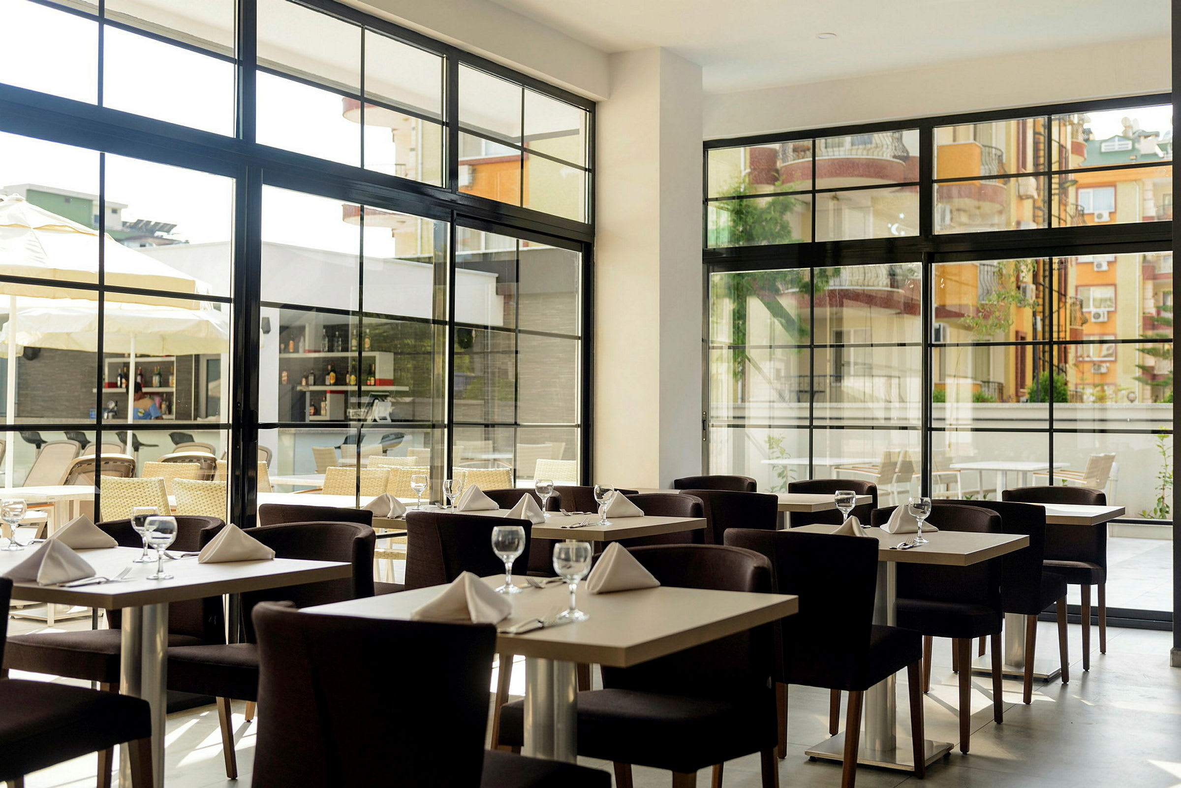 Restaurang med dukade bord och stora fönster. (AI-genererad text)