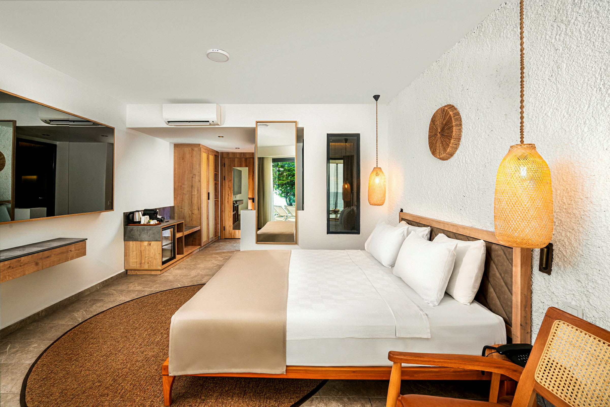 Ett modernt hotellrum med en dubbelsäng, ljus inredning och trämöbler. (AI-genererad text)