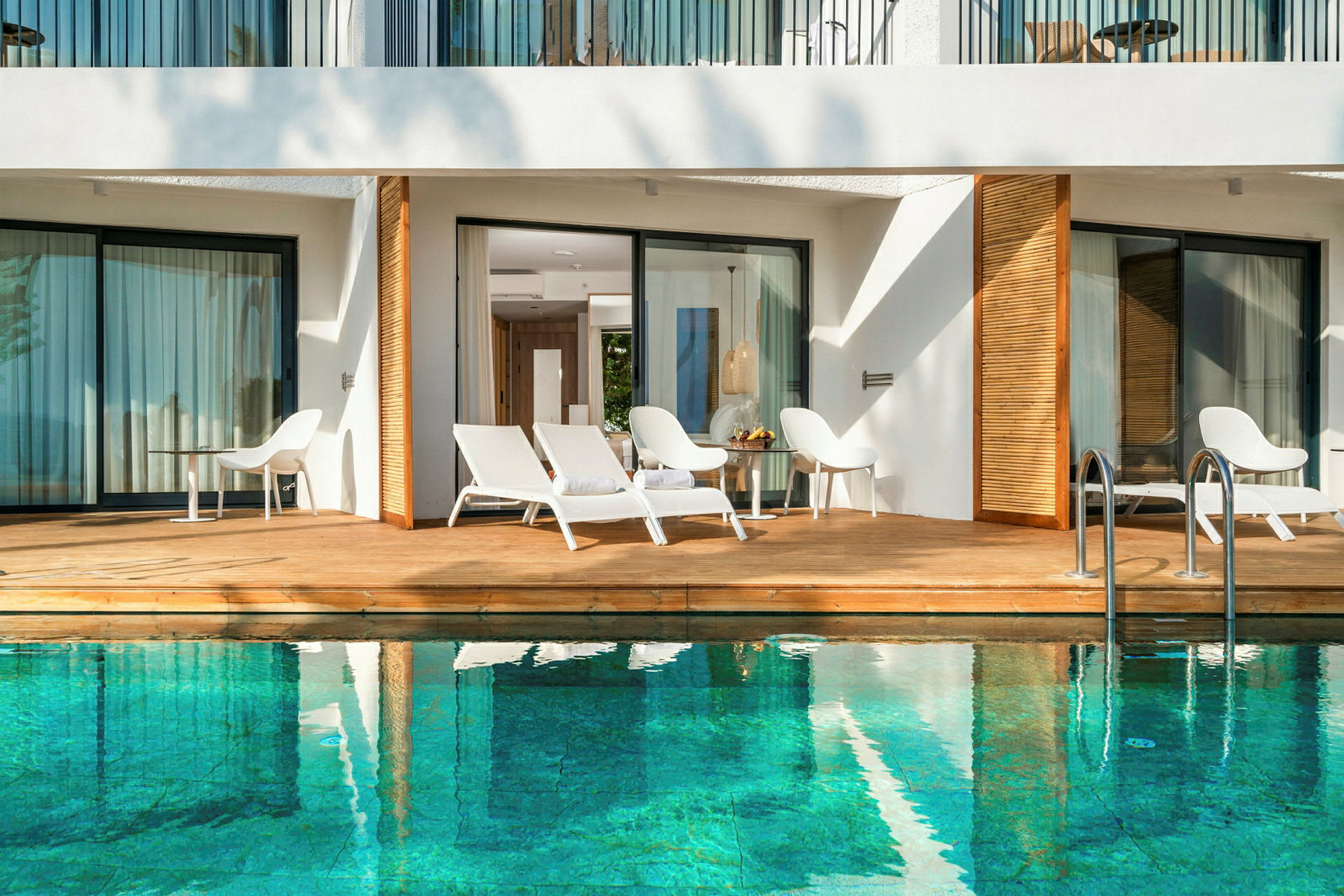 Terrass vid pool med solstolar och bord. (AI-genererad text)