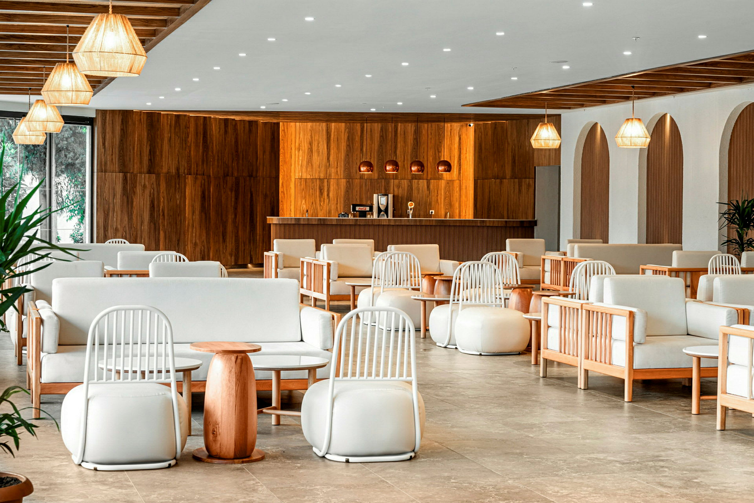 En hotelllobby med träpaneler, sittmöbler och hängande lampor. (AI-genererad text)