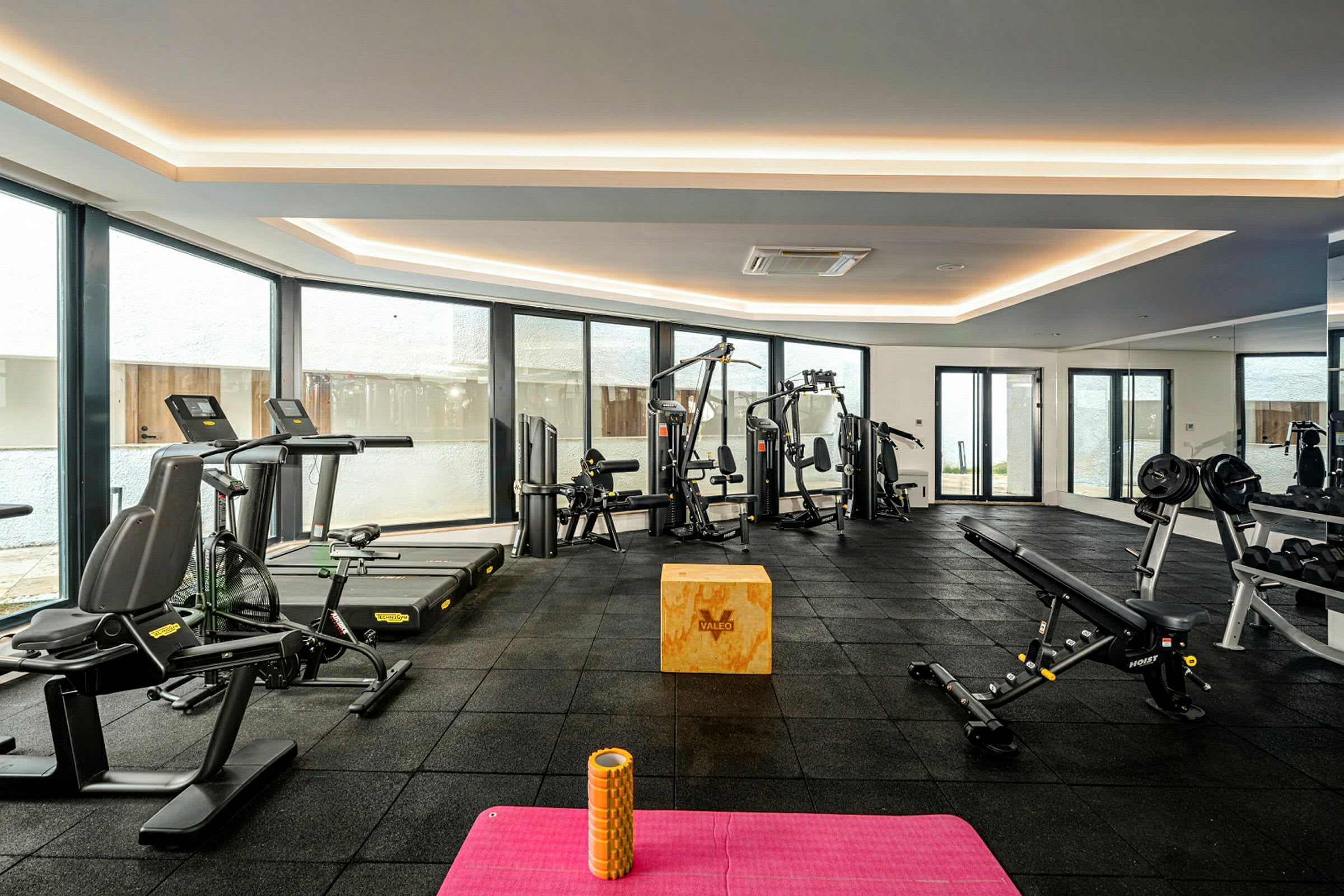 Ett gym med träningsmaskiner och utrustning. (AI-genererad text)
