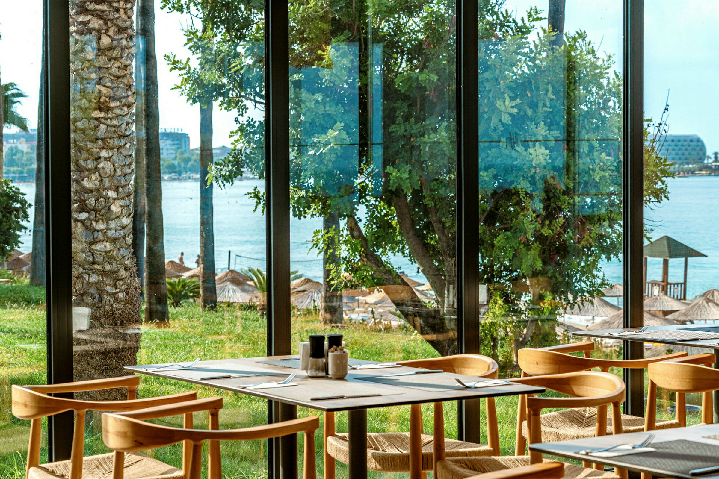 Restaurang med utsikt över stranden genom fönster. (AI-genererad text)