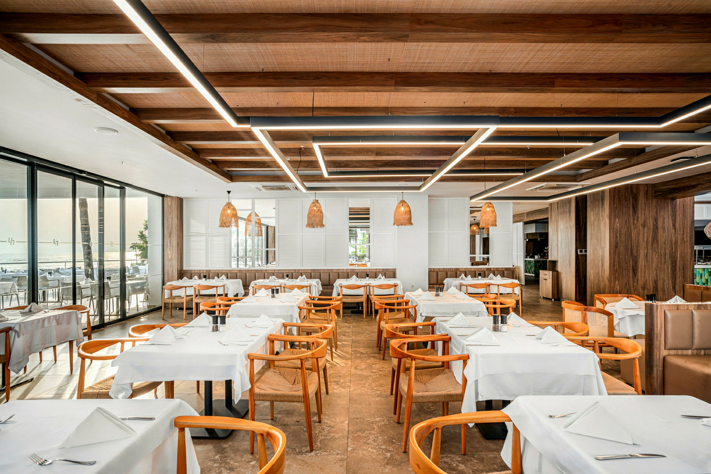 En restaurang med trästolar och vitt dukade bord. (AI-genererad text)