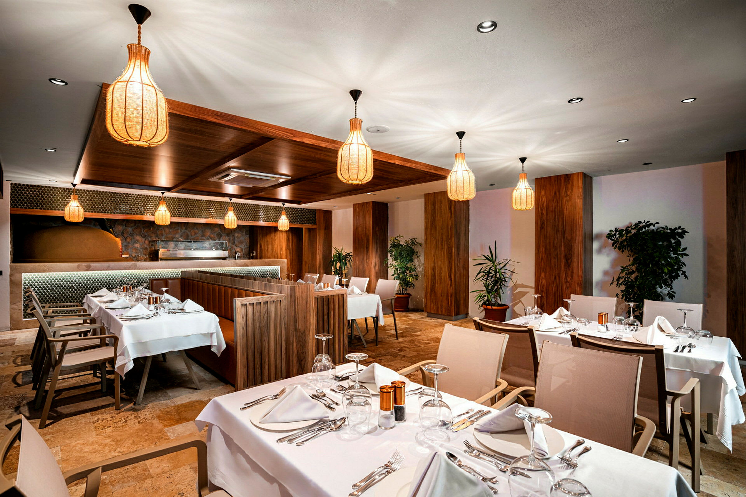 Interiör av en restaurang med dukade bord och elegant belysning. (AI-genererad text)
