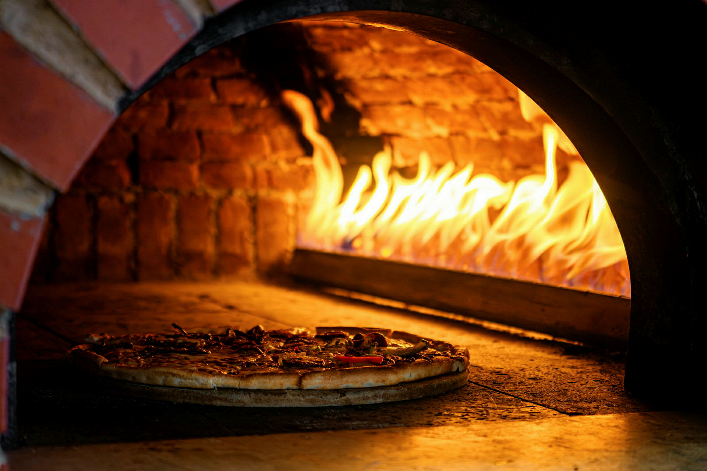 Vedeldad ugn med en pizza som gräddas. (AI-genererad text)