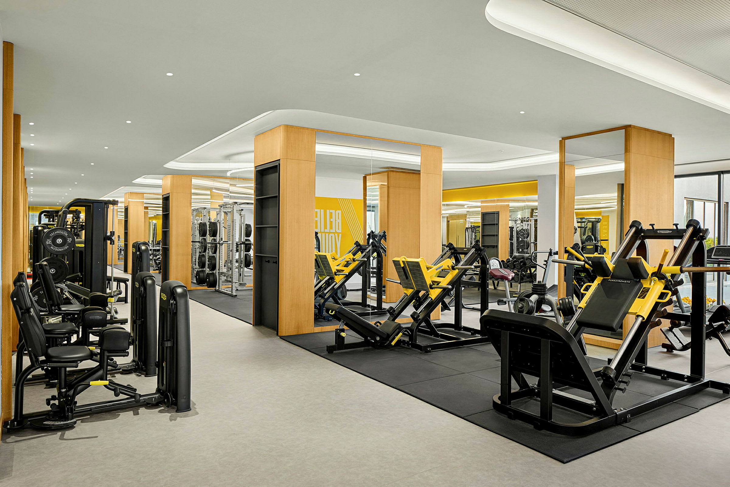 Ett modernt gym med träningsmaskiner och speglar. (AI-genererad text)