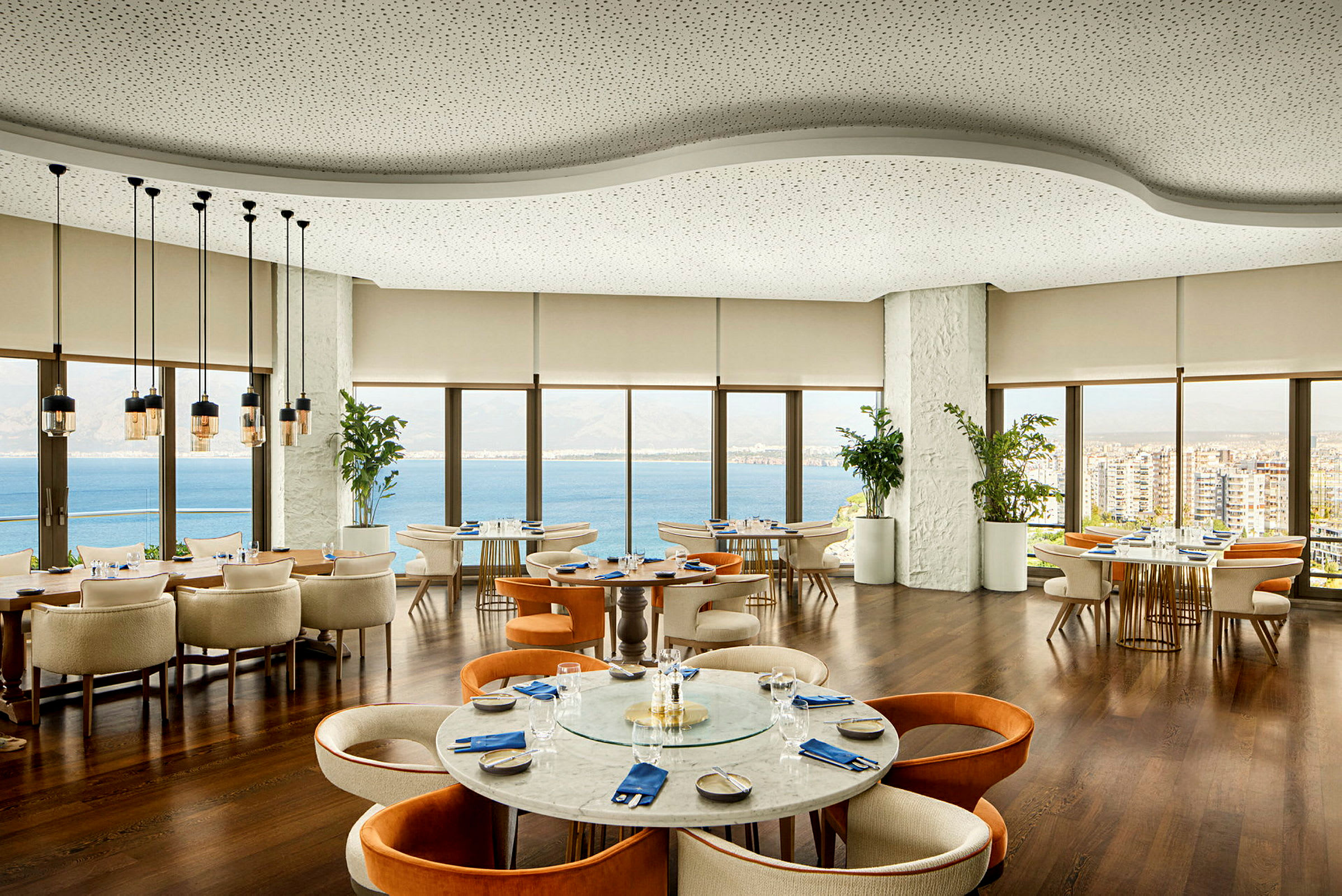 Modern restaurang med panoramautsikt mot havet och staden. (AI-genererad text)