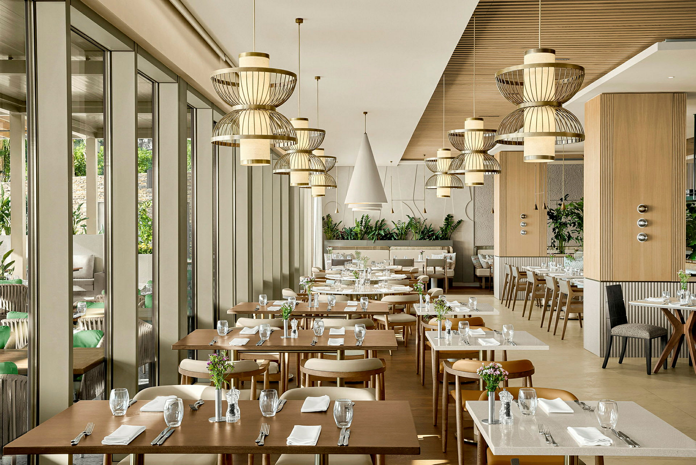En modern restaurang med eleganta bord och stolar samt dekorativa taklampor. (AI-genererad text)