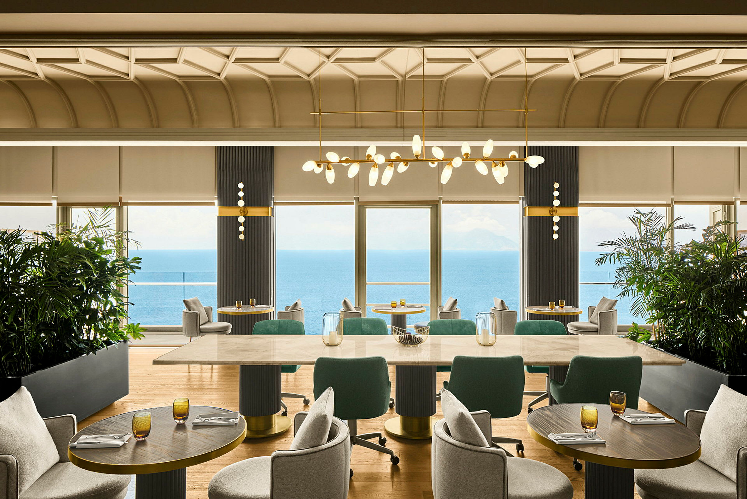 Ett välutrustat restaurangområde med stora fönster som erbjuder utsikt över havet. (AI-genererad text)