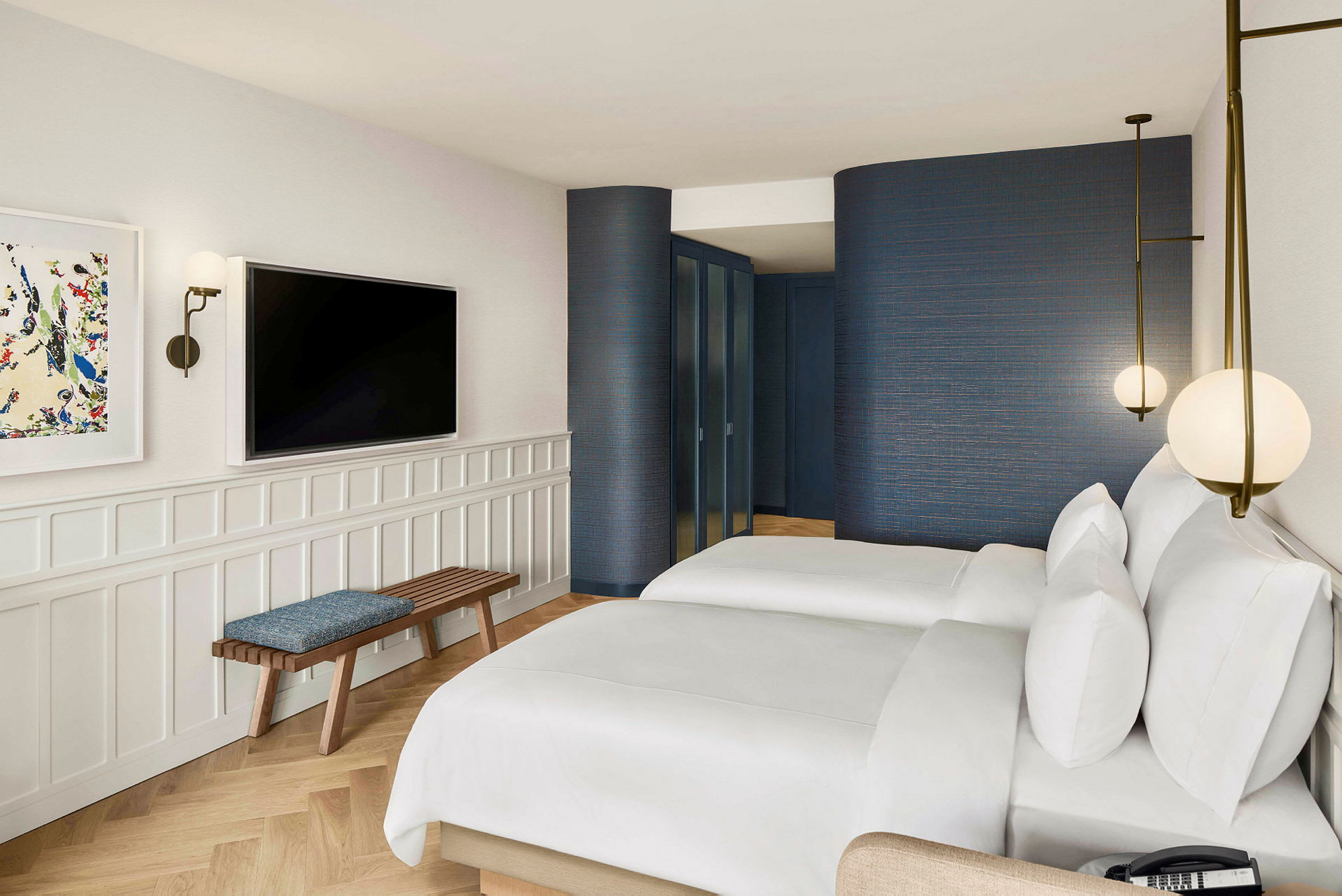 Ett hotellrum med två sängar, vägg med en tv och en sittbänk. (AI-genererad text)