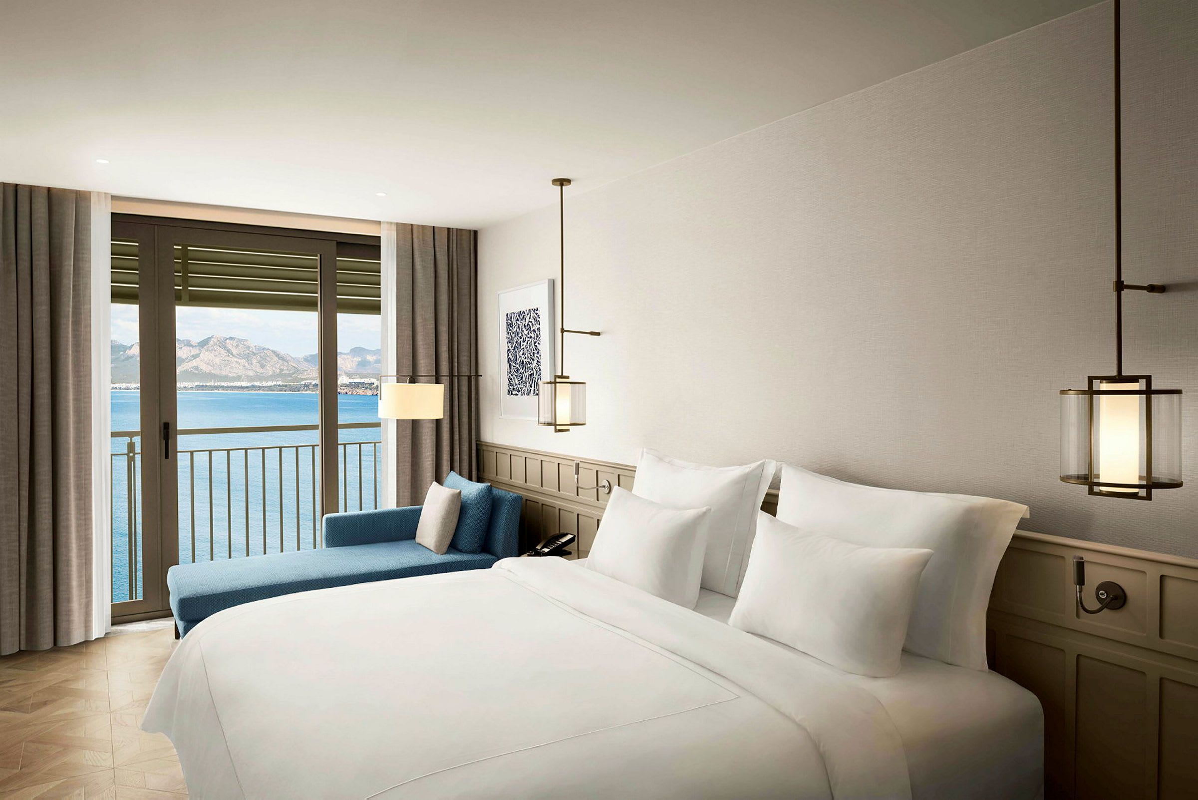 Ett hotellrum med bäddad säng och sittmöbler, fönster med utsikt mot hav och berg. (AI-genererad text)