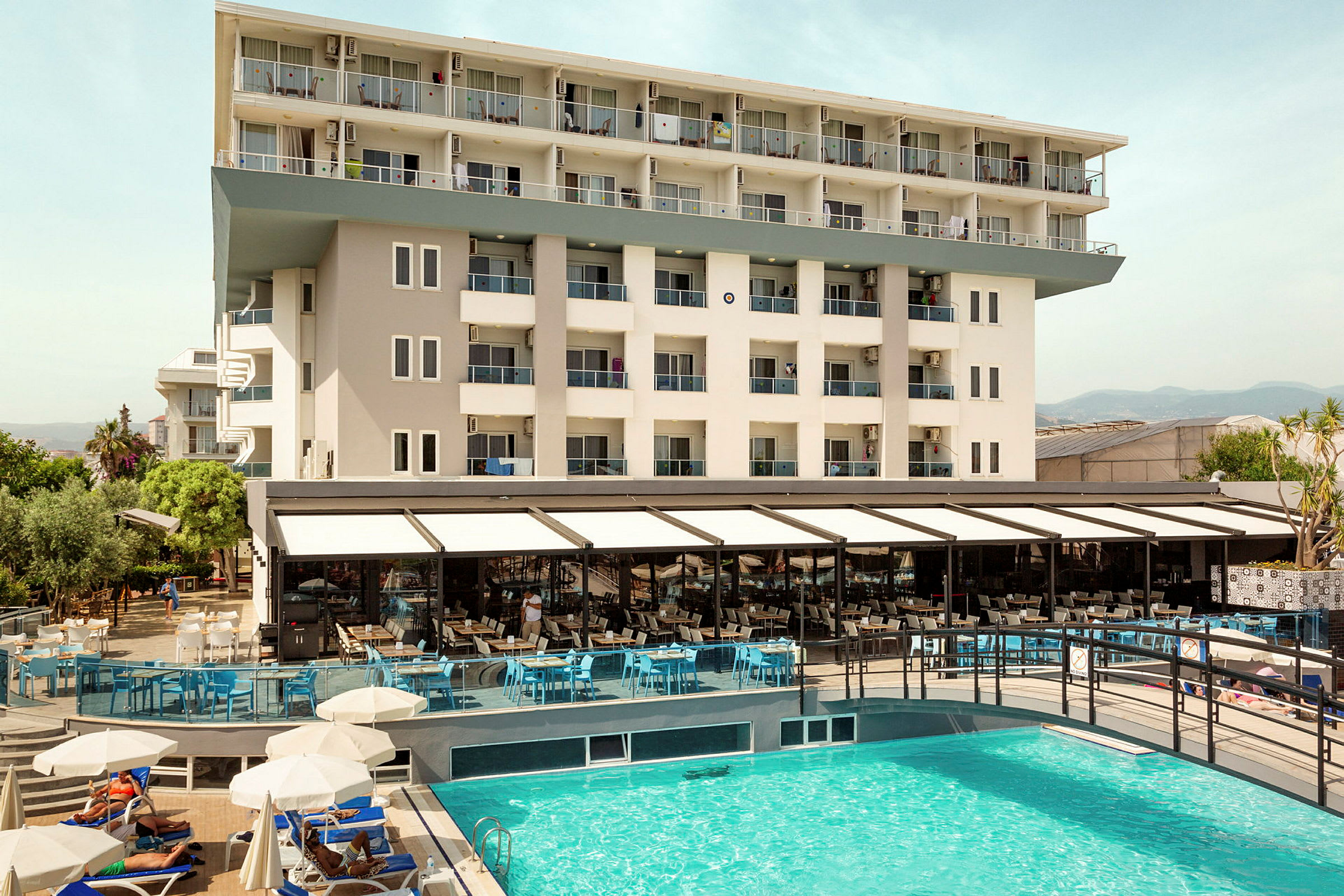Vy av hotellbyggnad och utomhuspool. (AI-genererad text)