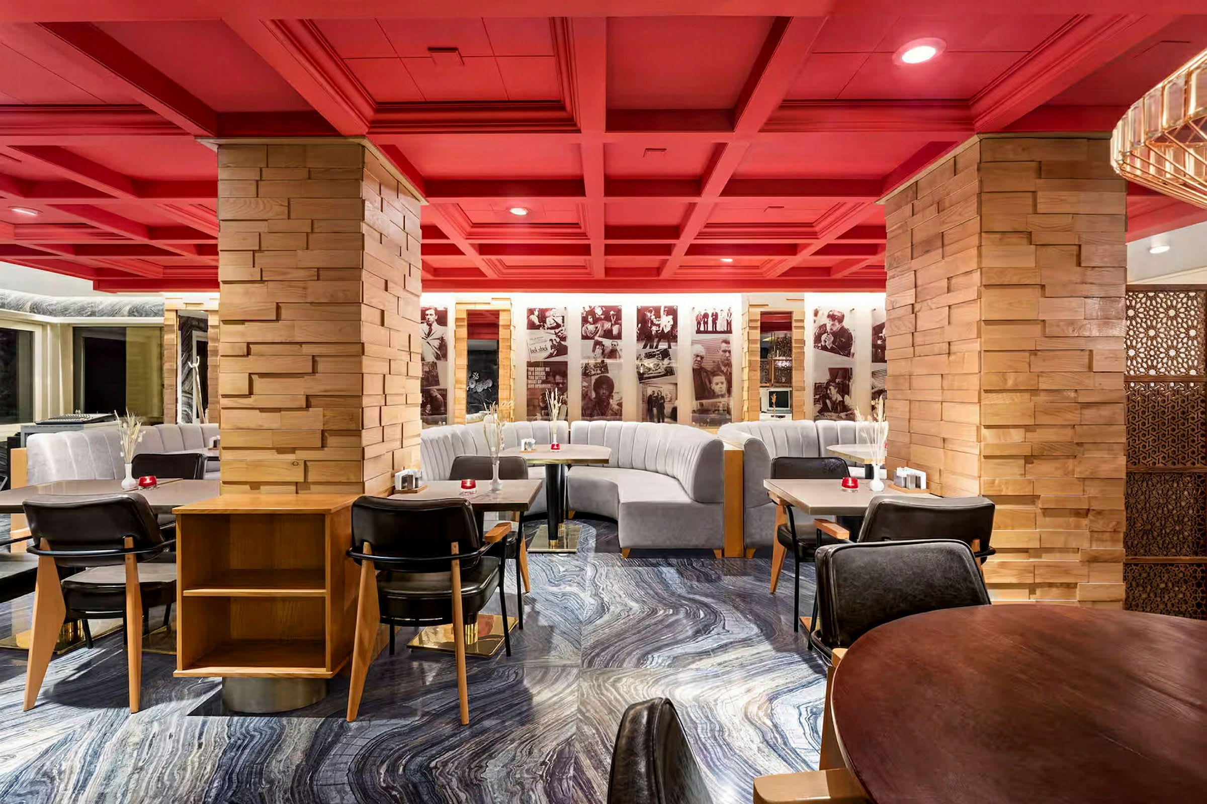 En restaurang med röda tak och träpelare samt grå soffor och moderna matbord. (AI-genererad text)