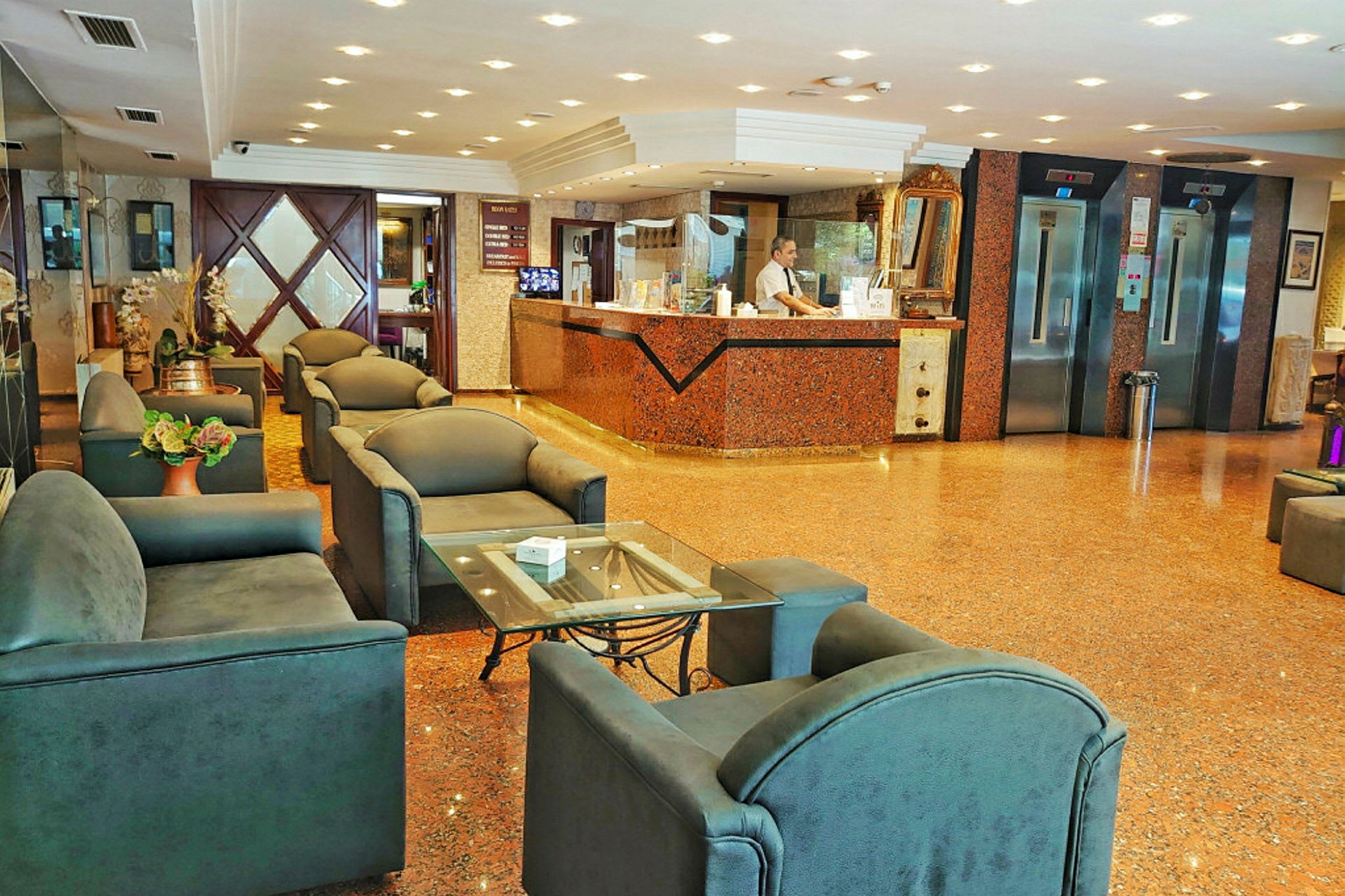 Bild av ett hotellobbyområde med en receptionsdisk, sittgrupper och hissar. (AI-genererad text)