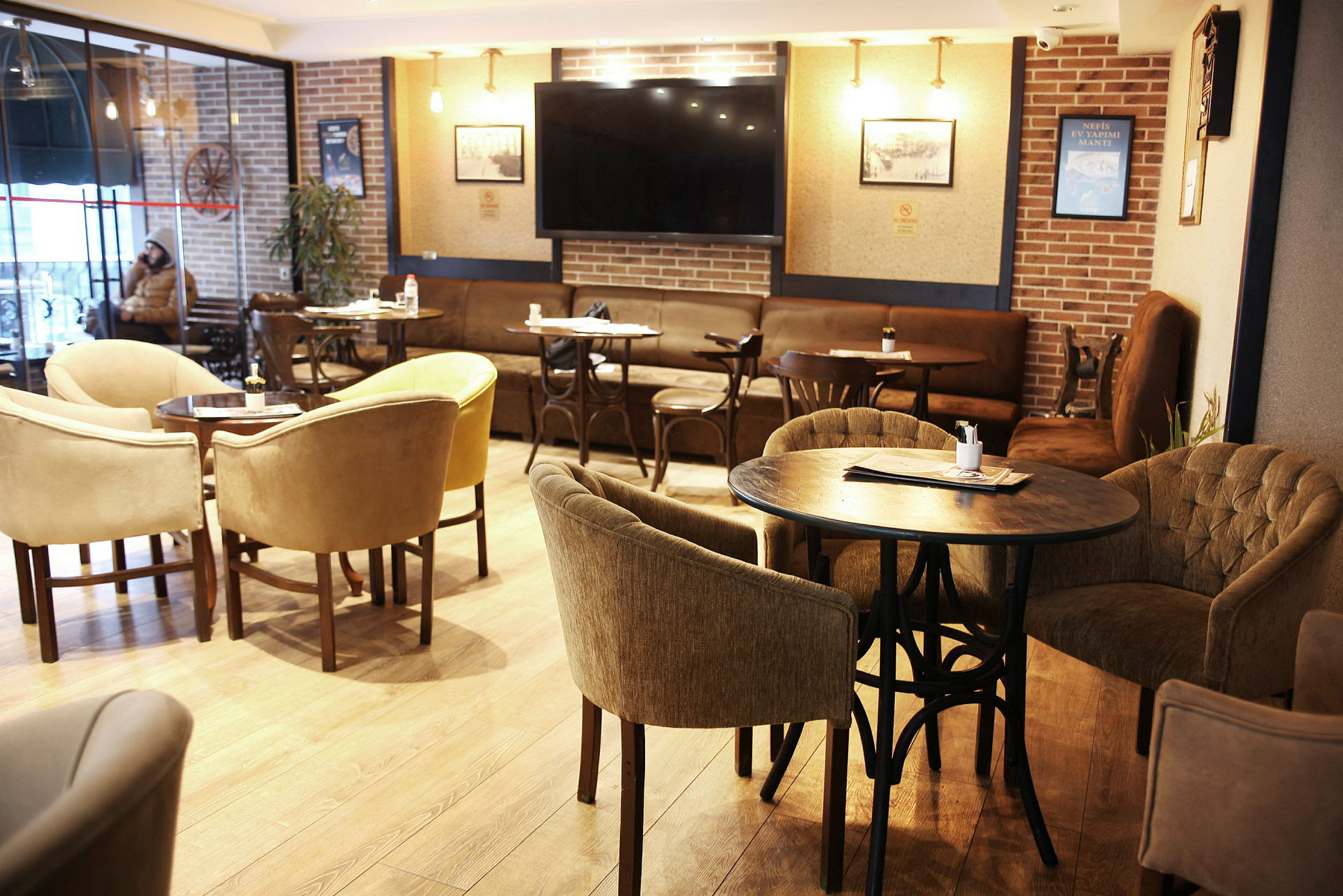 Interiör av en kafé- eller restauranglokal med bord och stolar i olika stilar. (AI-genererad text)