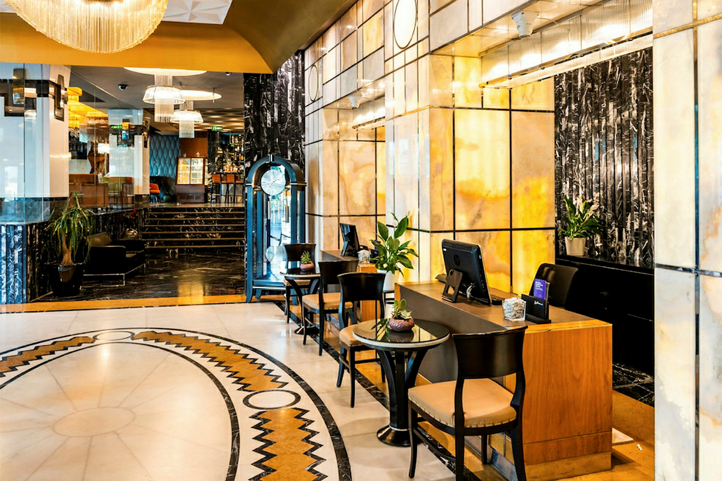 Ett elegant hotellobbyområde med marmorväggar, en reception och sittplatser. (AI-genererad text)