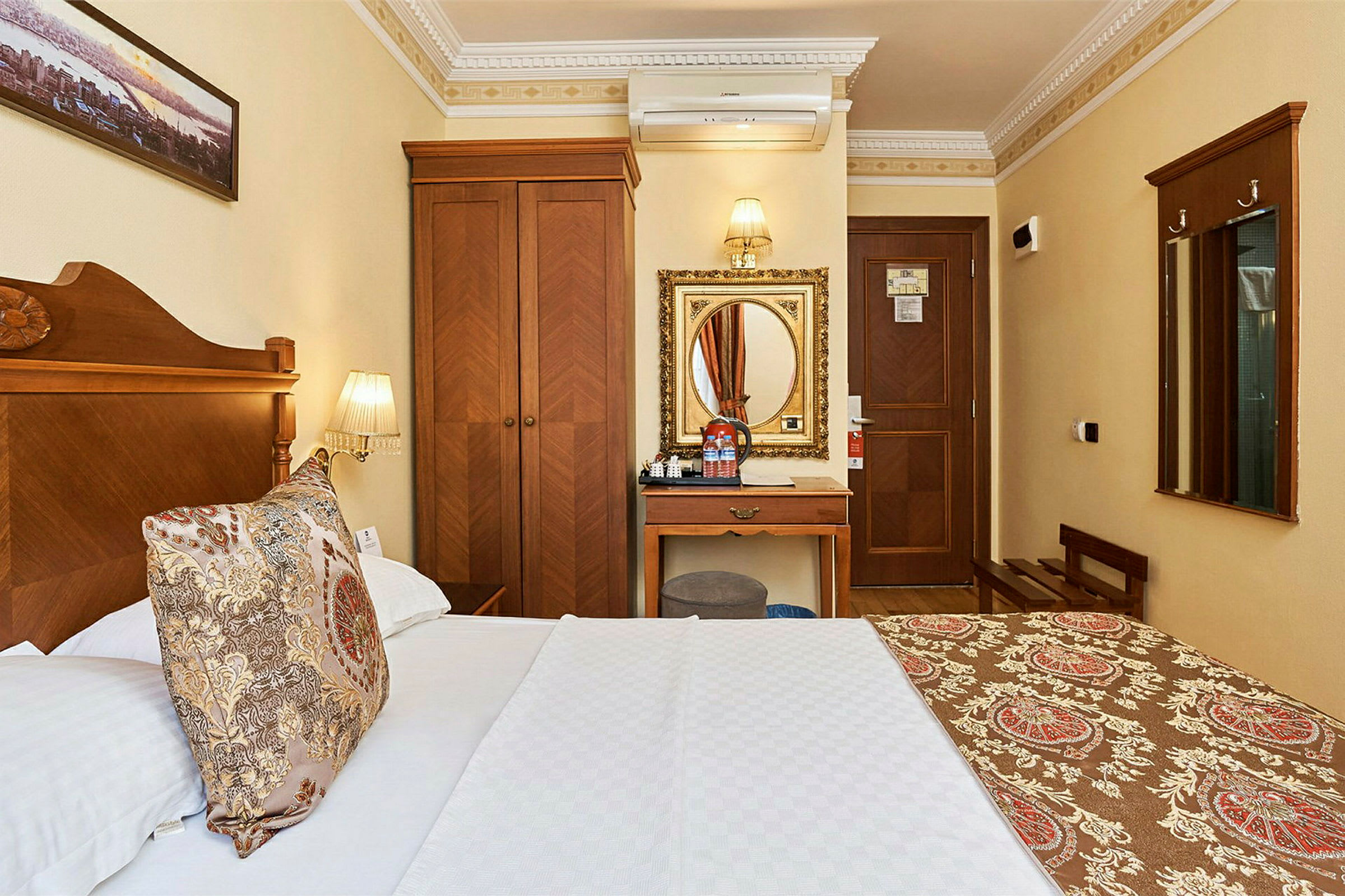 Hotellrum med träinredning och en säng med ett mönstrat överkast. (AI-genererad text)