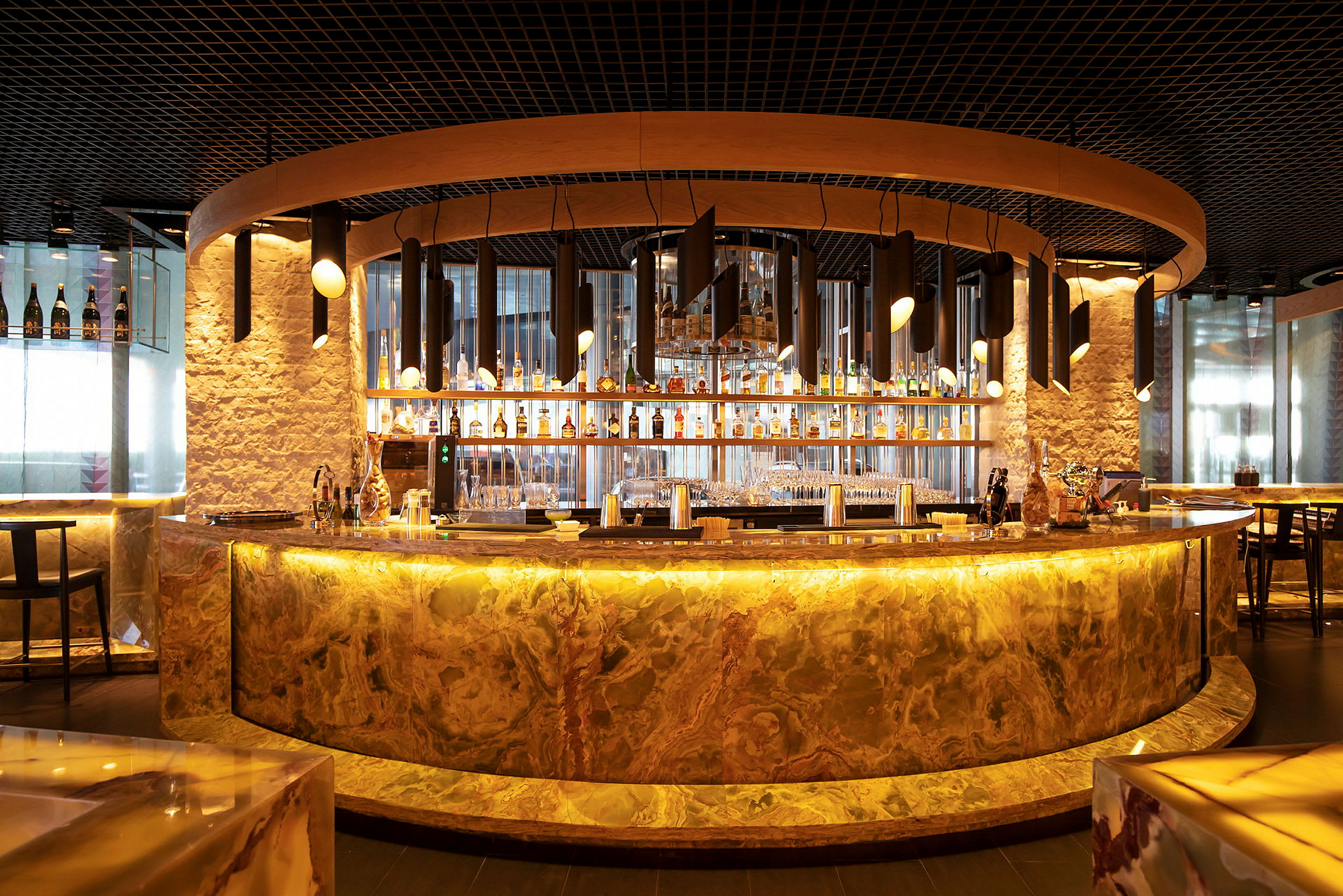 En välutformad bar med en bågformad marmorfront och modern belysning. (AI-genererad text)