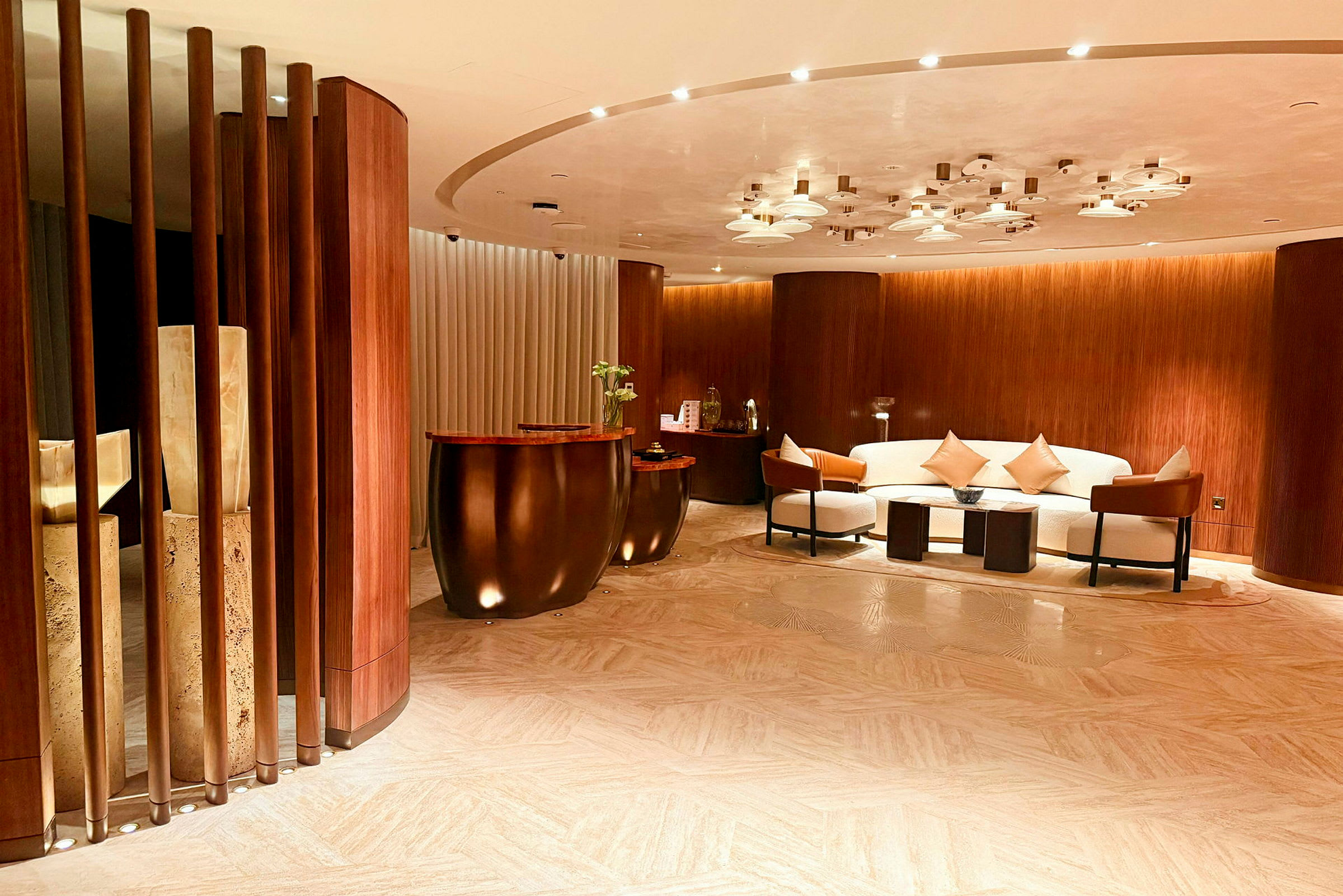 Ett stilfullt hotell- eller kontorsområde med soffgrupp, soffbord och marmordetaljer, omgärdad av träpanelväggar. (AI-genererad text)