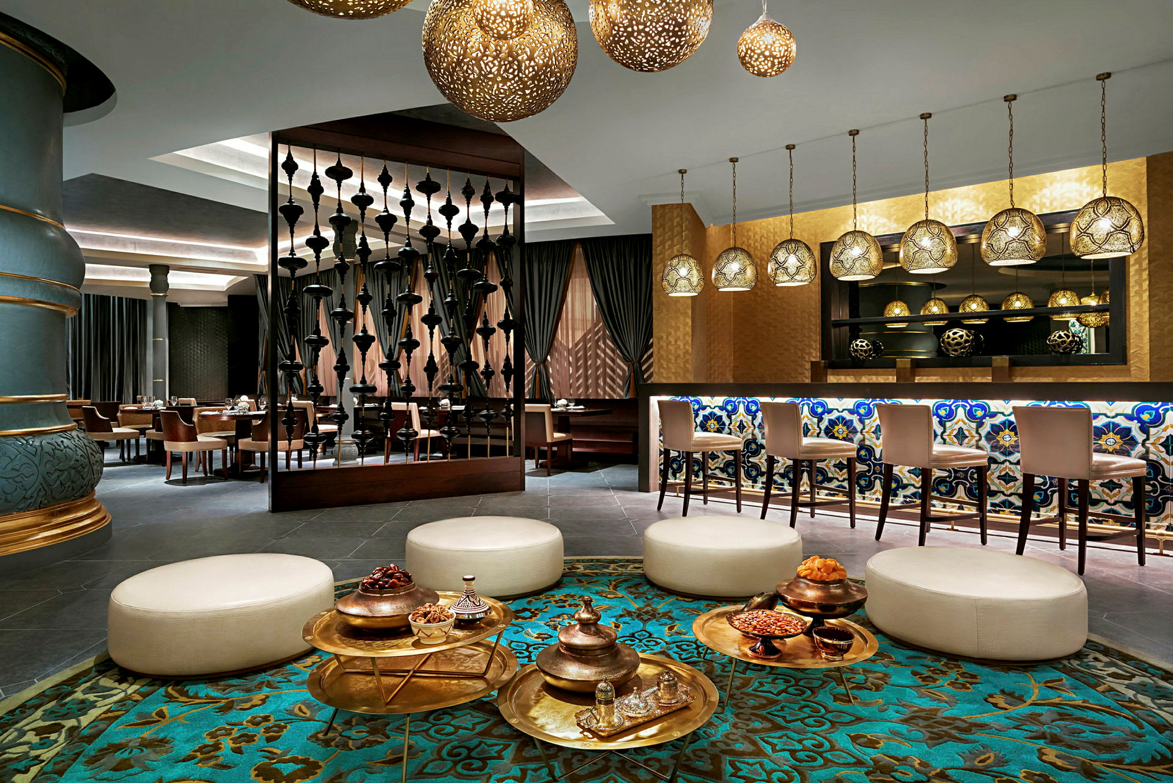 En elegant hotelllobby med sittgrupper, dekorativa lampor och en bar med mosaikdetaljer. (AI-genererad text)