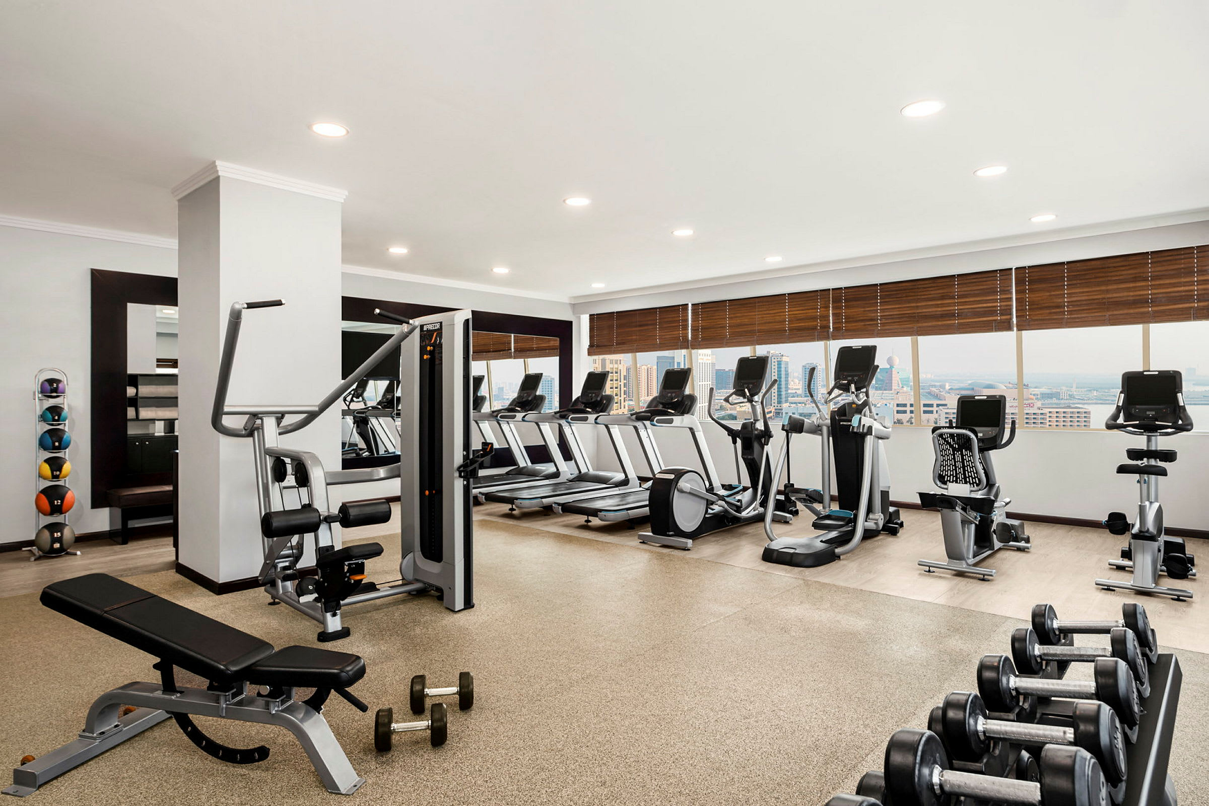Ett gym innehållande träningsmaskiner, löpband, vikter och motionscyklar. (AI-genererad text)