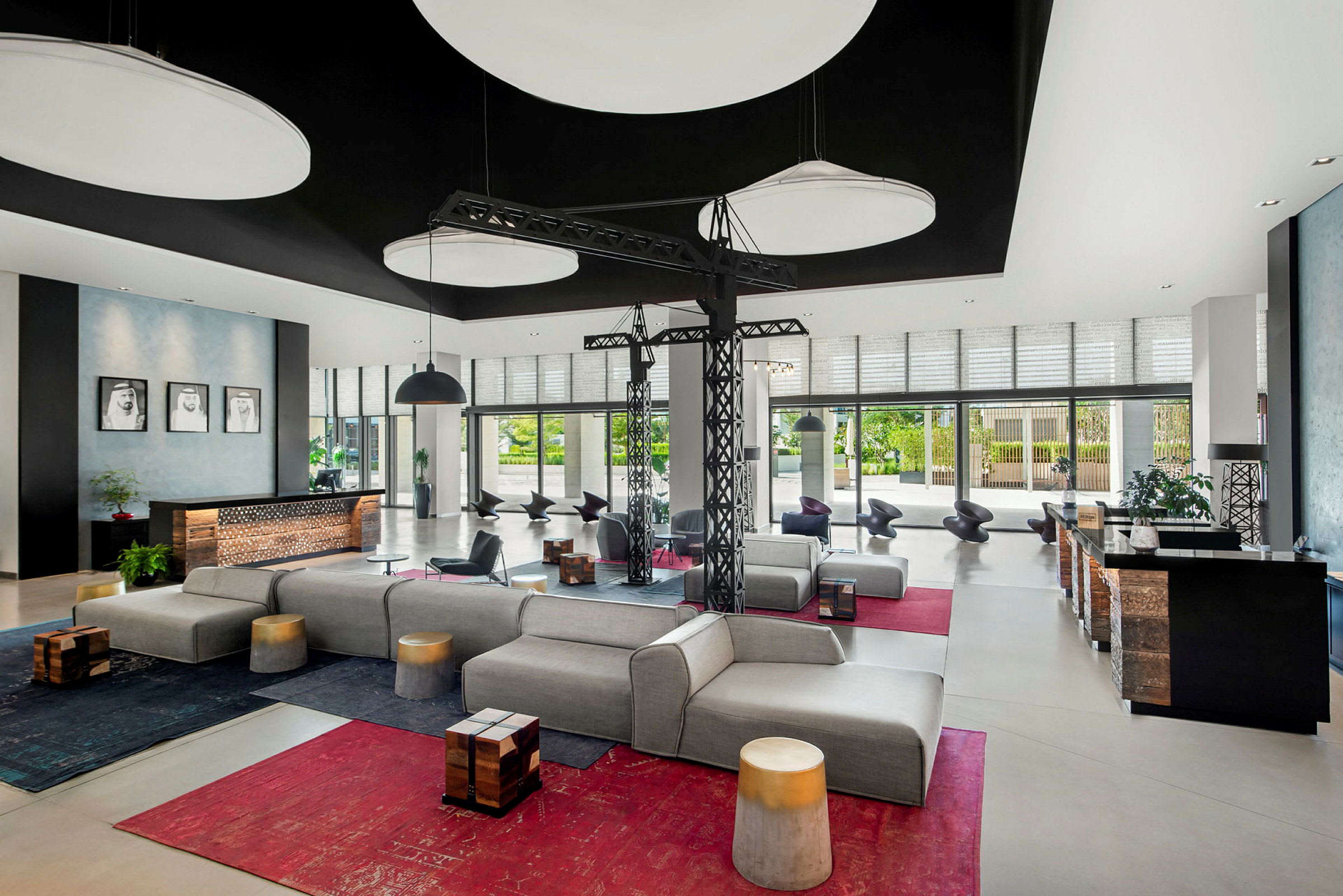 En modern hotellobby med bekväma sittmöbler, designbelysning och stora fönster som släpper in naturligt ljus. (AI-genererad text)
