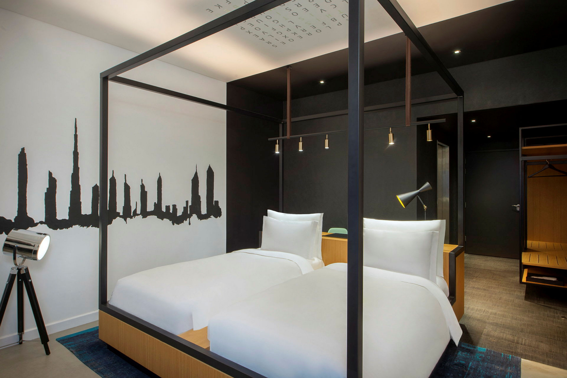 Ett modernt hotellrum med två sängar, svartvita väggdekorationer och minimalistisk inredning. (AI-genererad text)