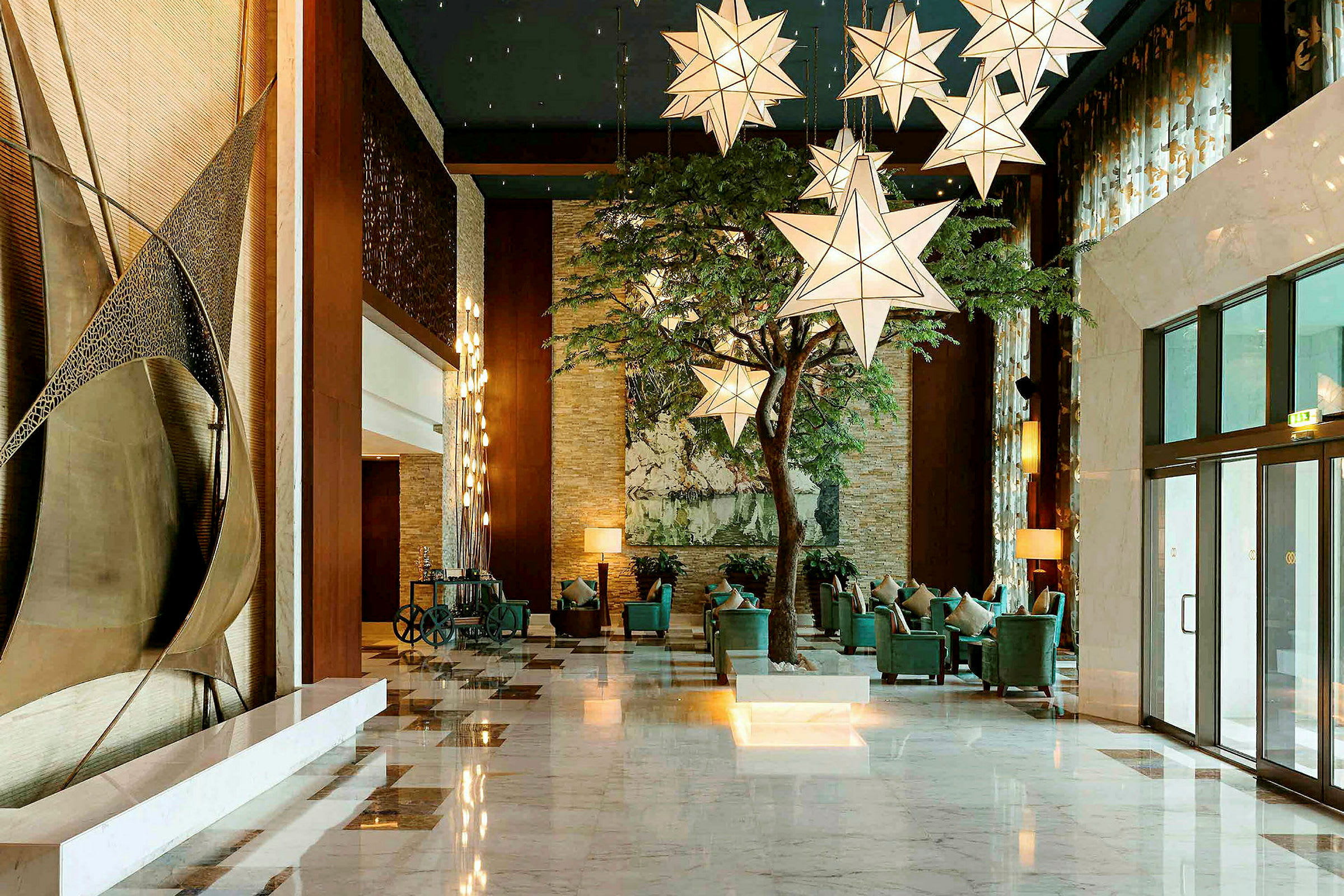 Hotellets lobby med stjärnformade ljuskronor och sittplatser. (AI-genererad text)