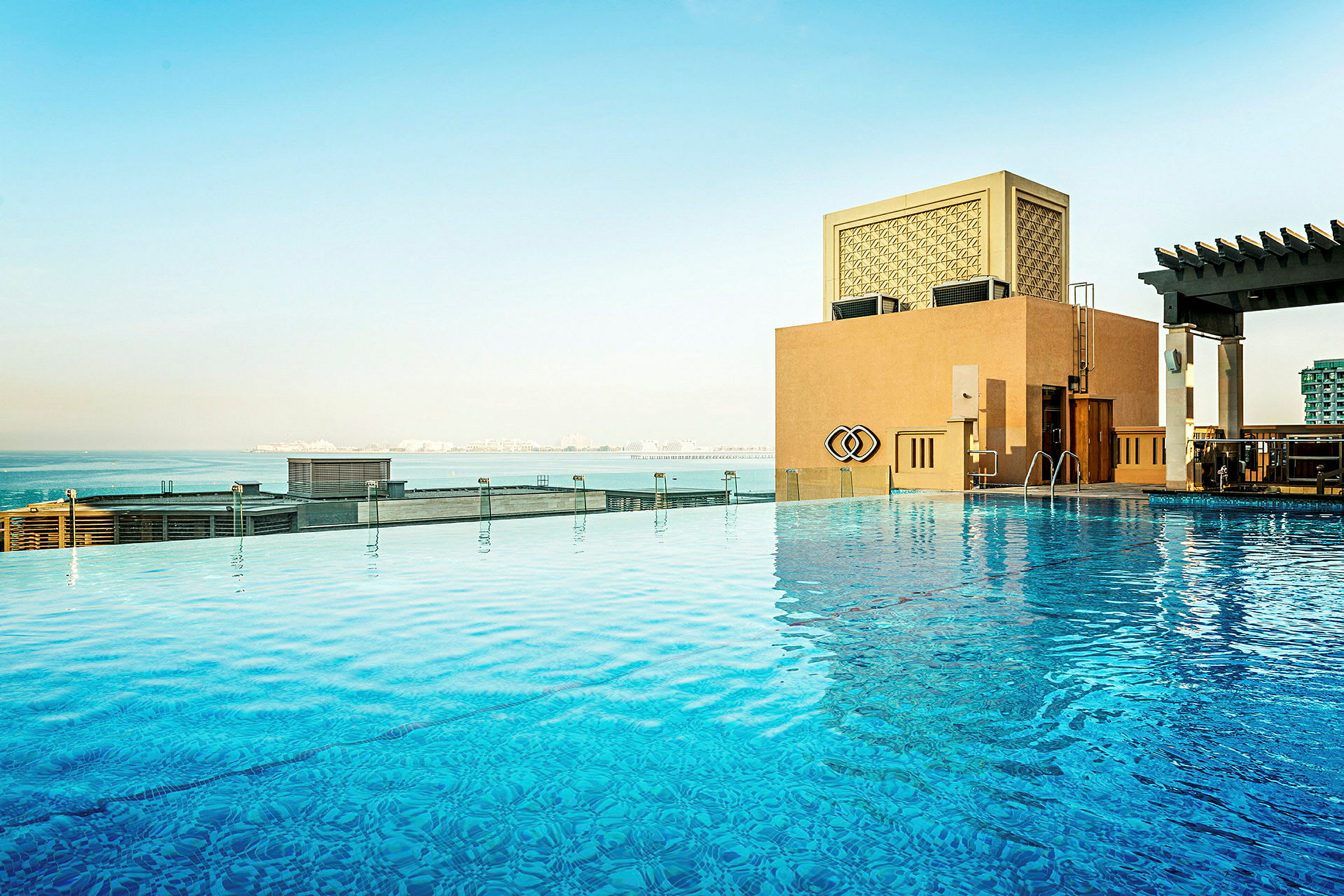 En infinitypool med utsikt över havet och en byggnad. (AI-genererad text)