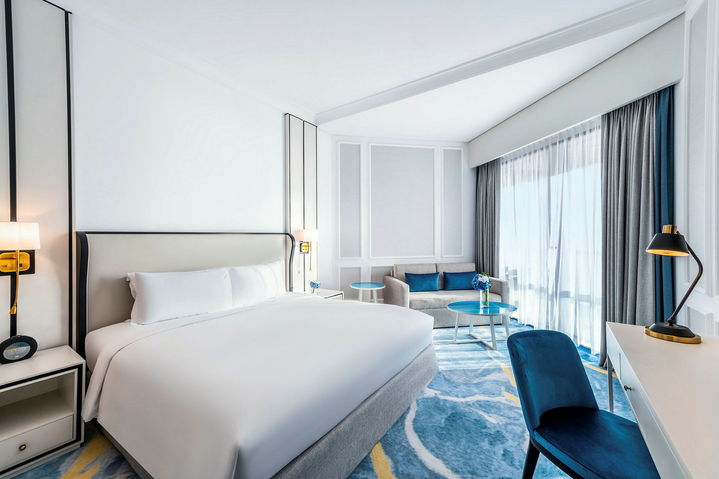 Ett hotellrum med en dubbelsäng, en soffa och ett skrivbord. (AI-genererad text)