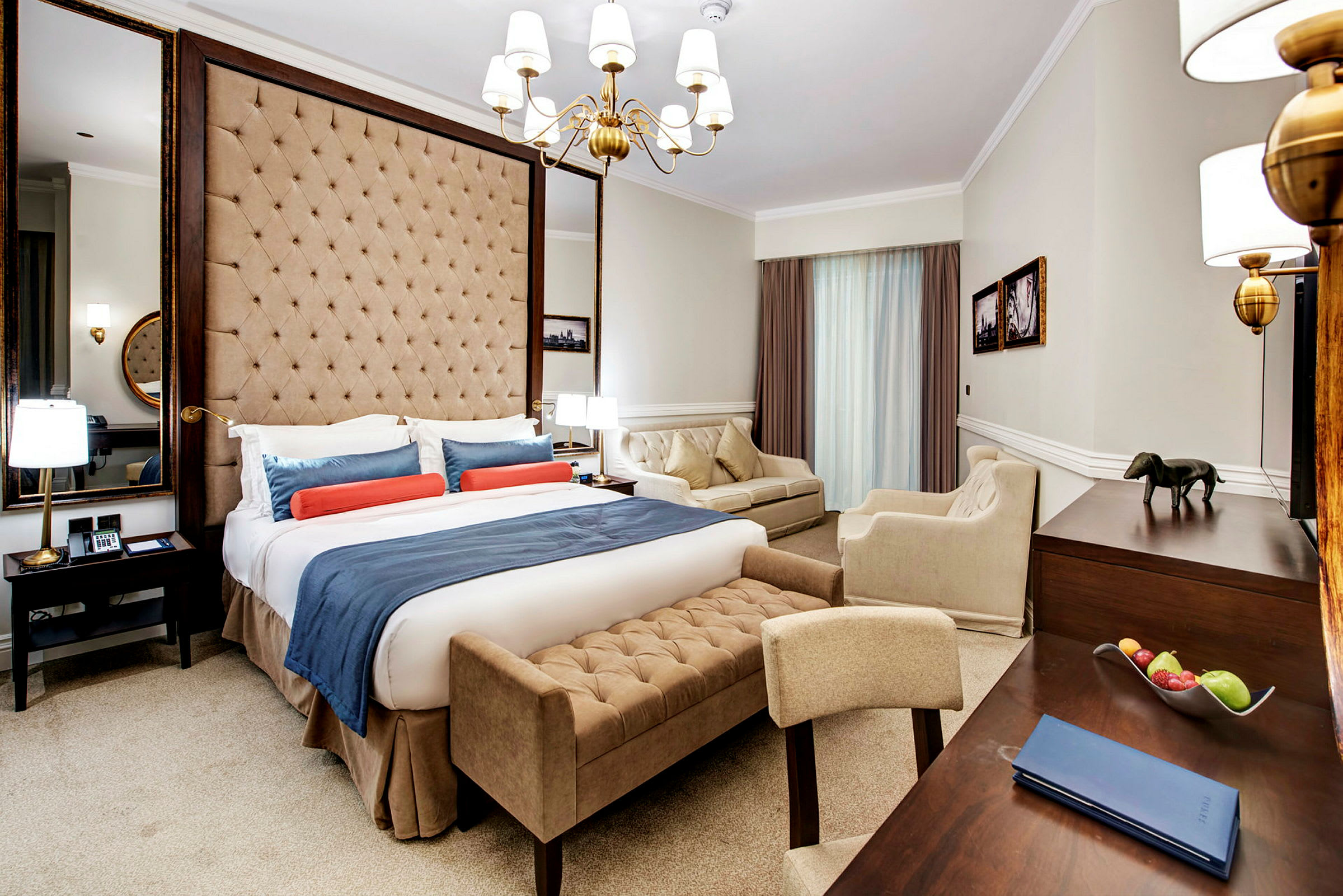 Ett elegant hotellrum med en stor säng, sittmöbler och skrivbord. (AI-genererad text)