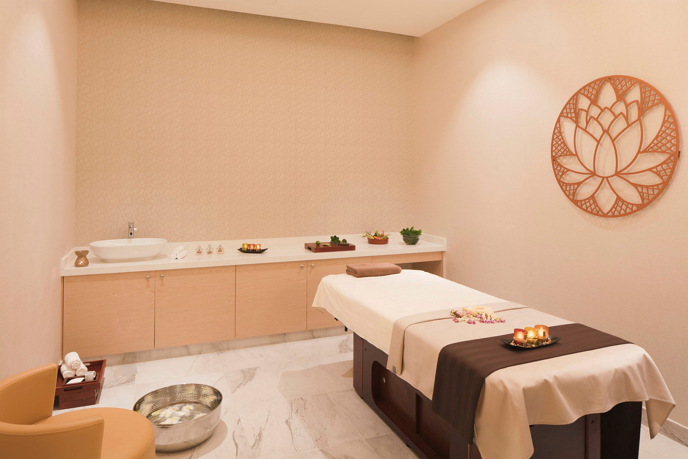 Ett spa-rum med en massagebänk, dekorativa ljus och handdukar. (AI-genererad text)