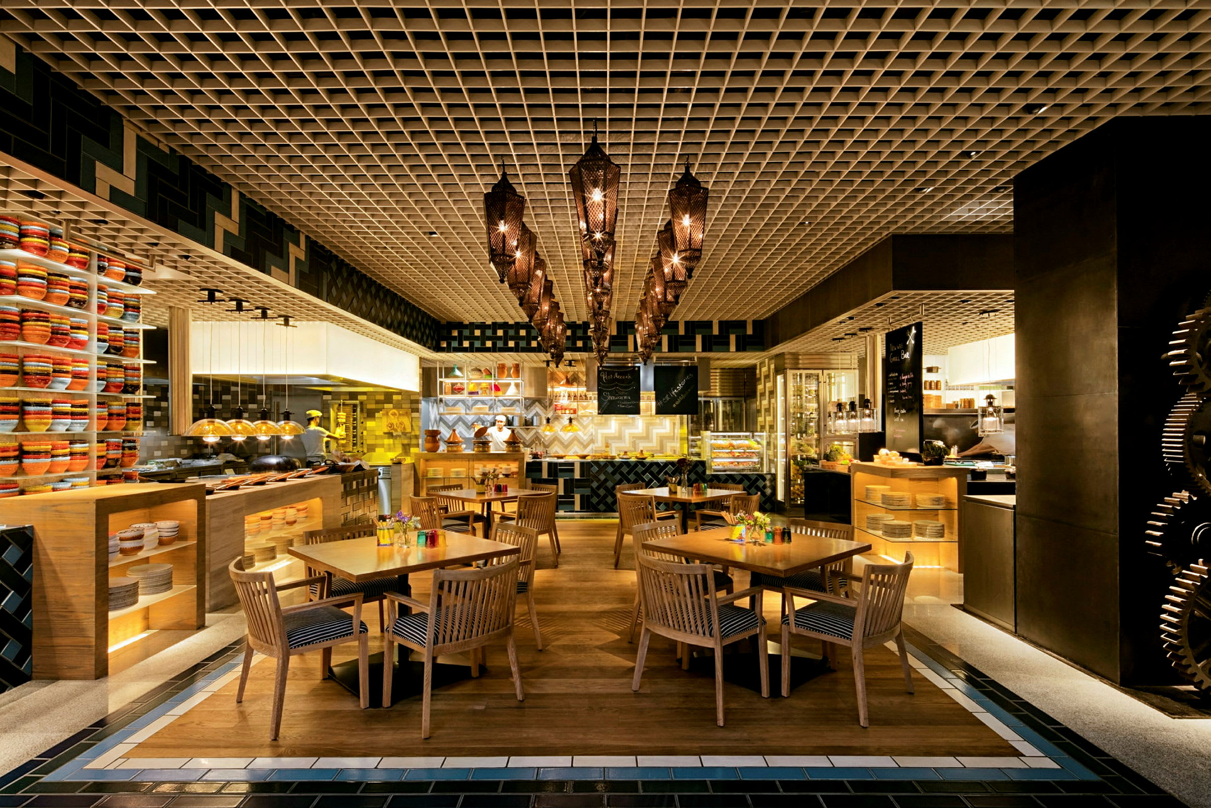 Restaurang med träbord och stolar, samt dekorativ belysning och hyllor med färgglada föremål. (AI-genererad text)