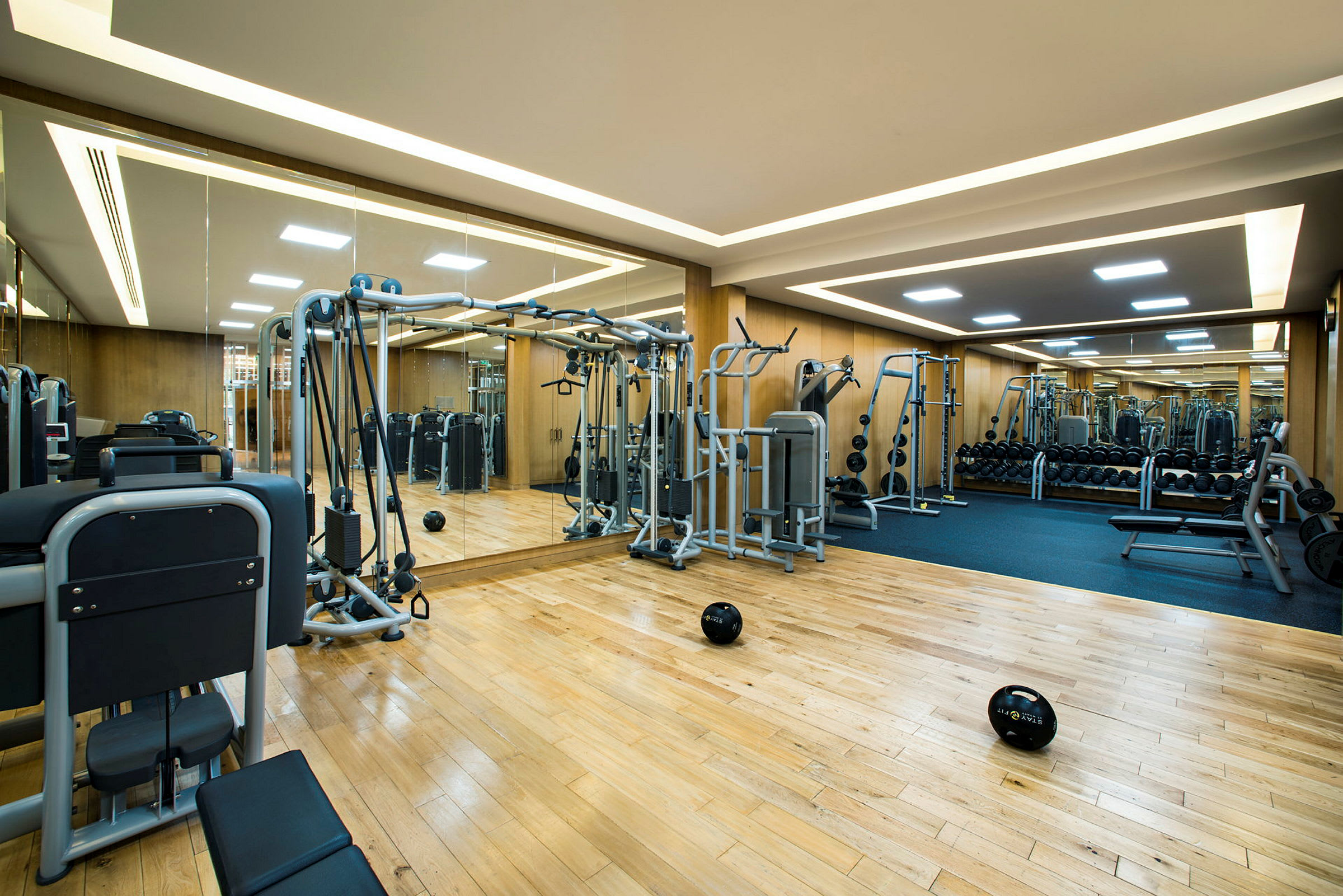 Gym med träningsutrustning och spegelvägg. (AI-genererad text)