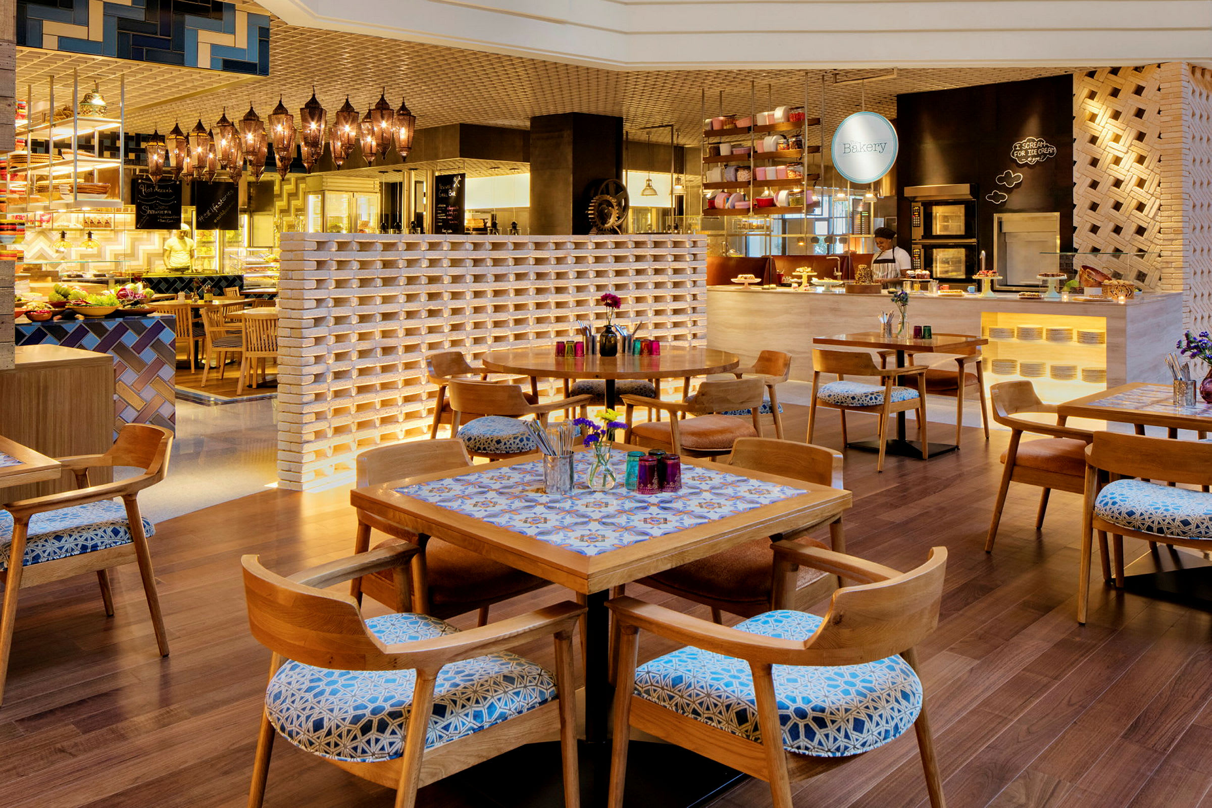 Inredningen av en charmig restaurang med trästolar och bord, dekorerad med blommor och färgglada detaljer. (AI-genererad text)