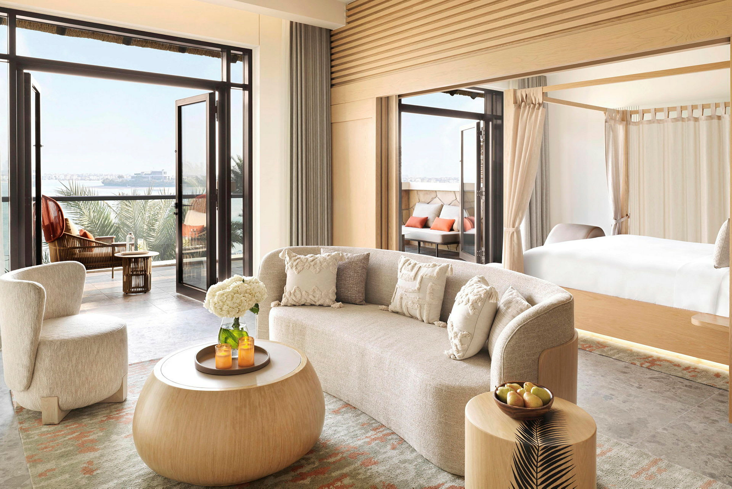 Modernt inredd hotellsvit med öppning till balkong och utsikt över havet. (AI-genererad text)