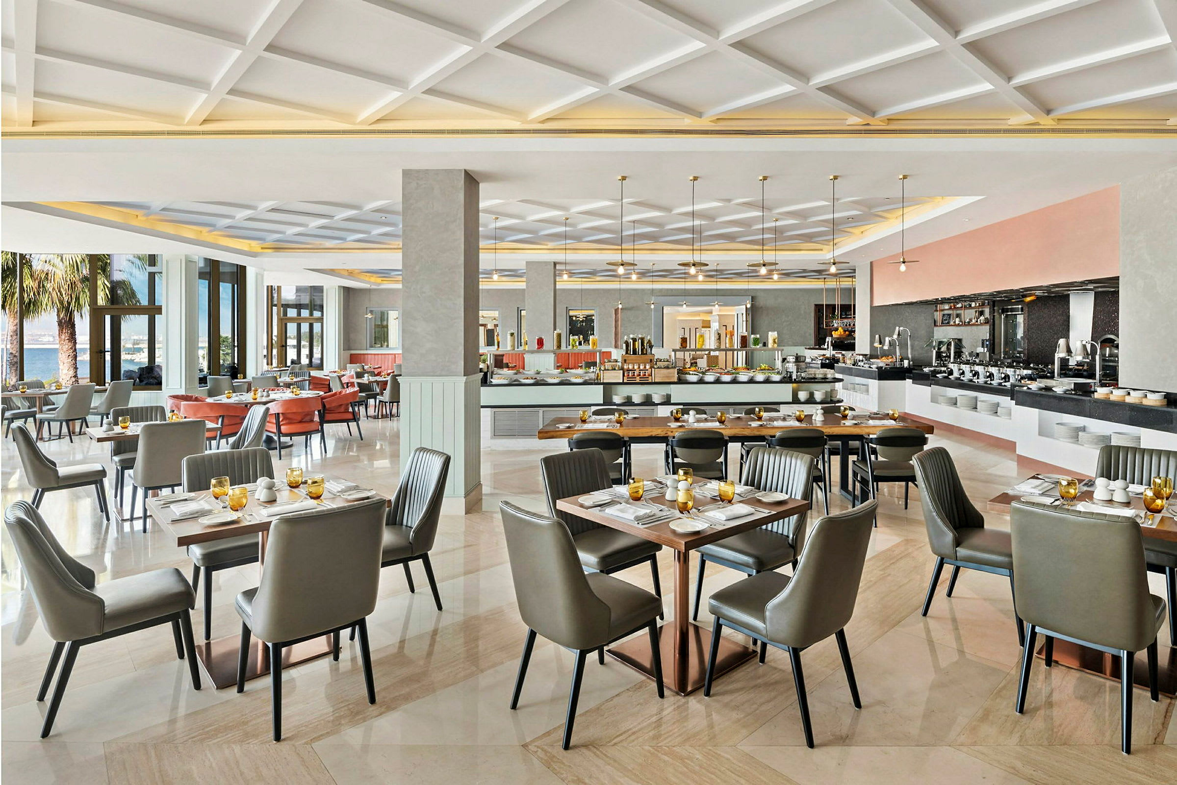 En rymlig och ljus restaurang med elegant inredning, dukade bord och stora fönster som släpper in naturligt ljus. (AI-genererad text)