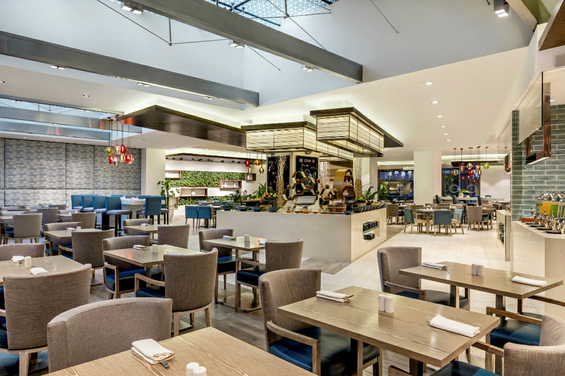 Restaurang med modern inredning, bord och stolar samt serveringsområde. (AI-genererad text)