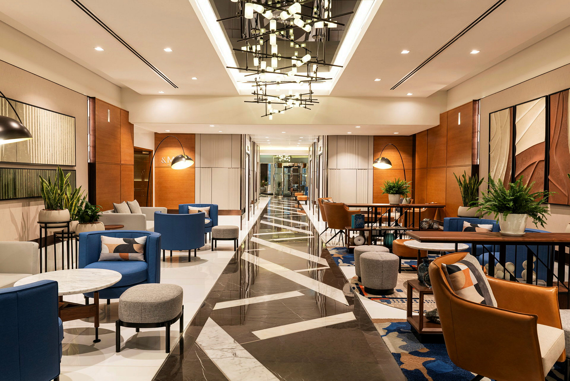 Ett modernt hotellobbyområde med sittgrupper, bord och belysning. (AI-genererad text)