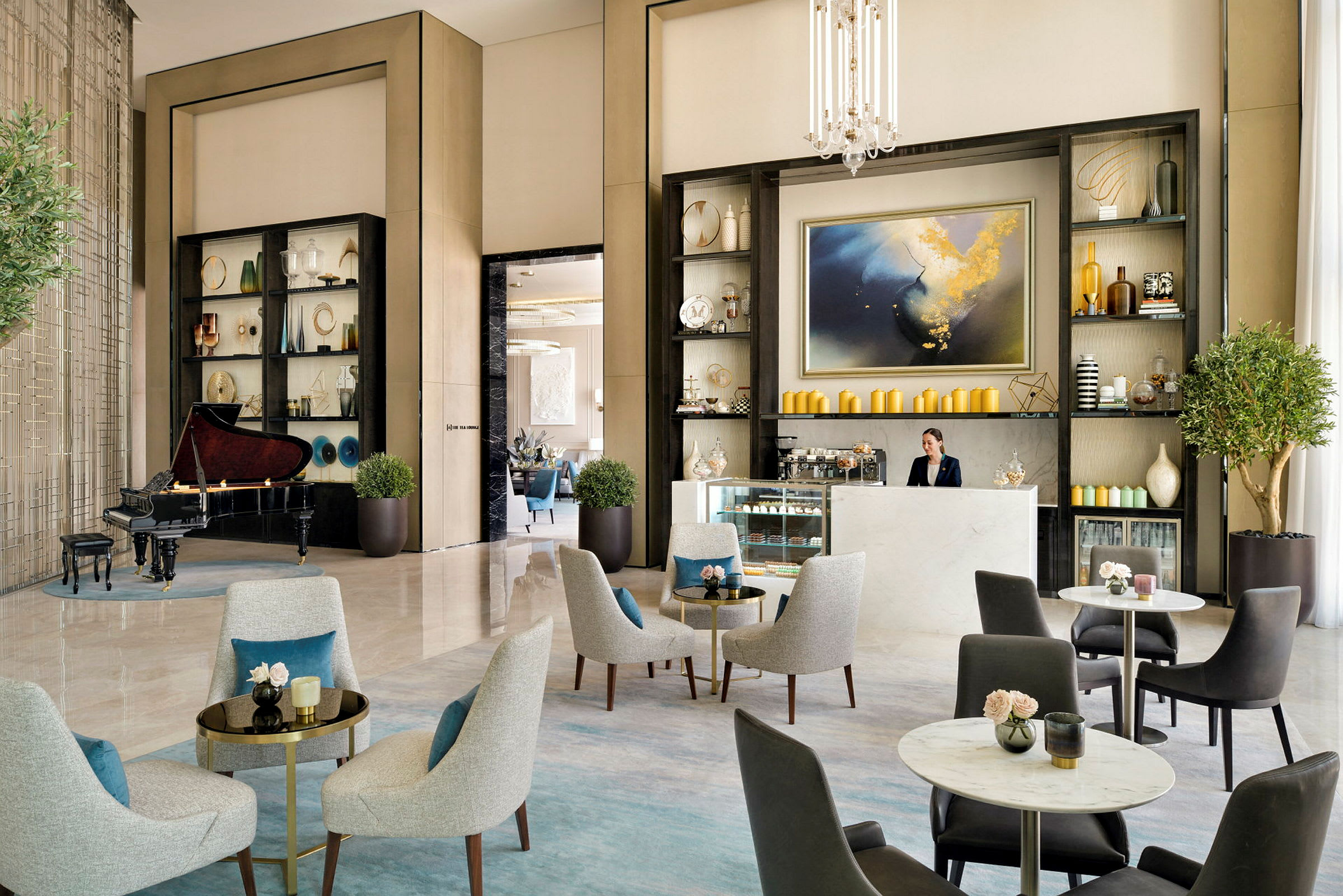Ett eleganta loungeområde med sittplatser, ett piano och en reception med hyllor dekorerade med vaser och konstföremål. (AI-genererad text)