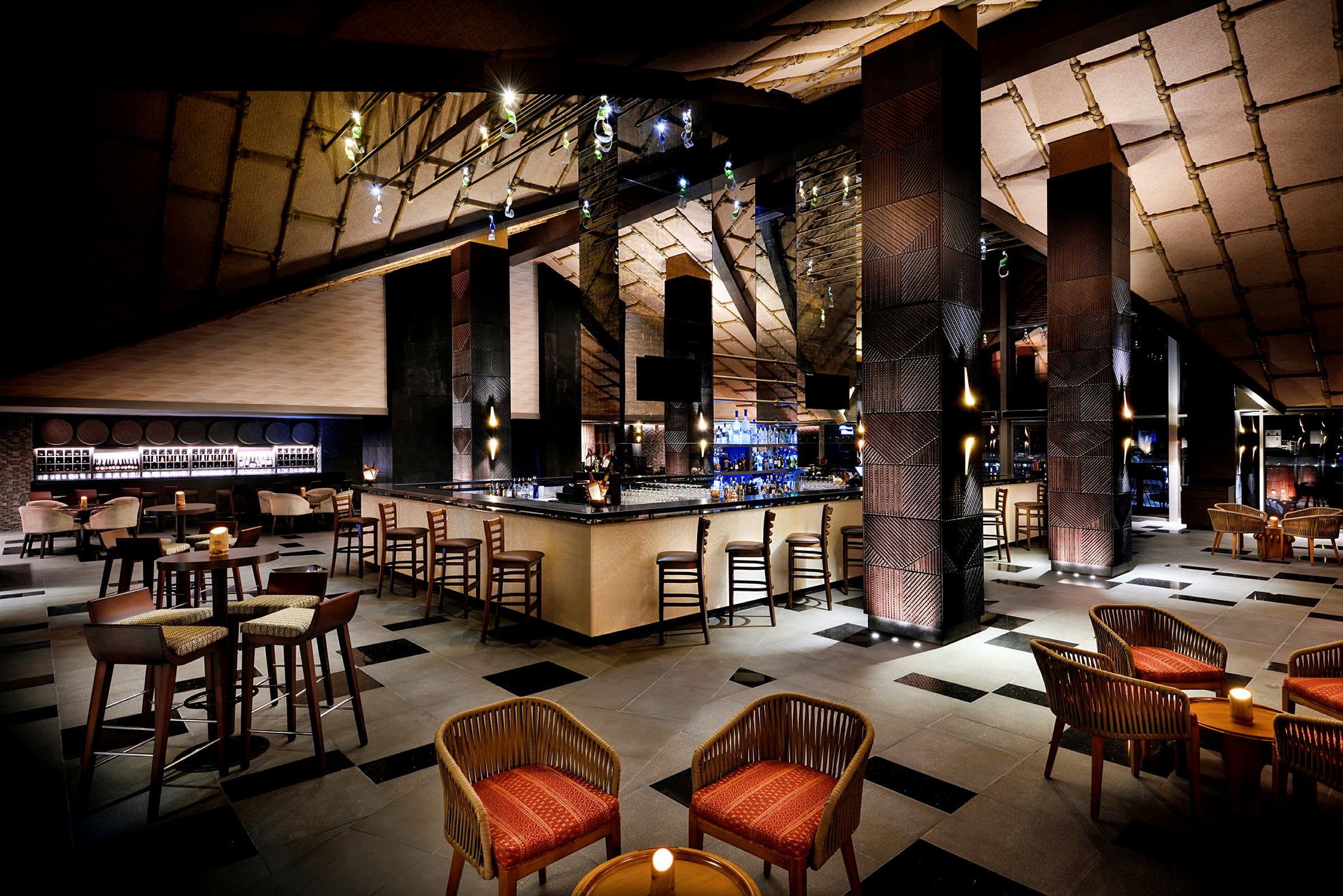 En elegant lounge med en central bardisk, sittgrupper med stolar och bord samt stämningsfull belysning. (AI-genererad text)